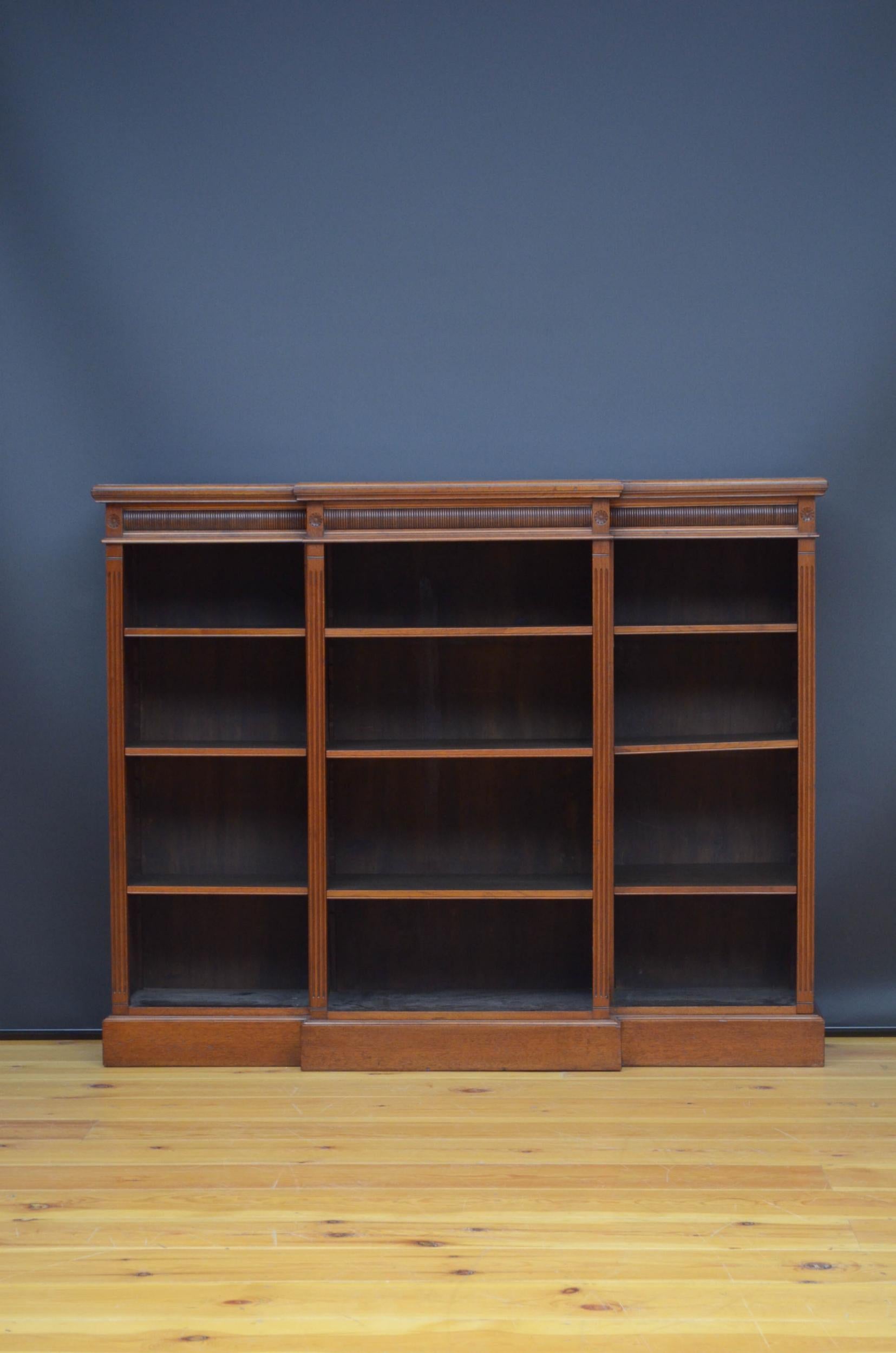 J03 A Victorian, break fronted bookcase in walnut with figured walnut top above concave reeded frieze and a projecting centre section, flanked by reeded pilasters and further open section also flanked by reeded piastres all fitted with nine height
