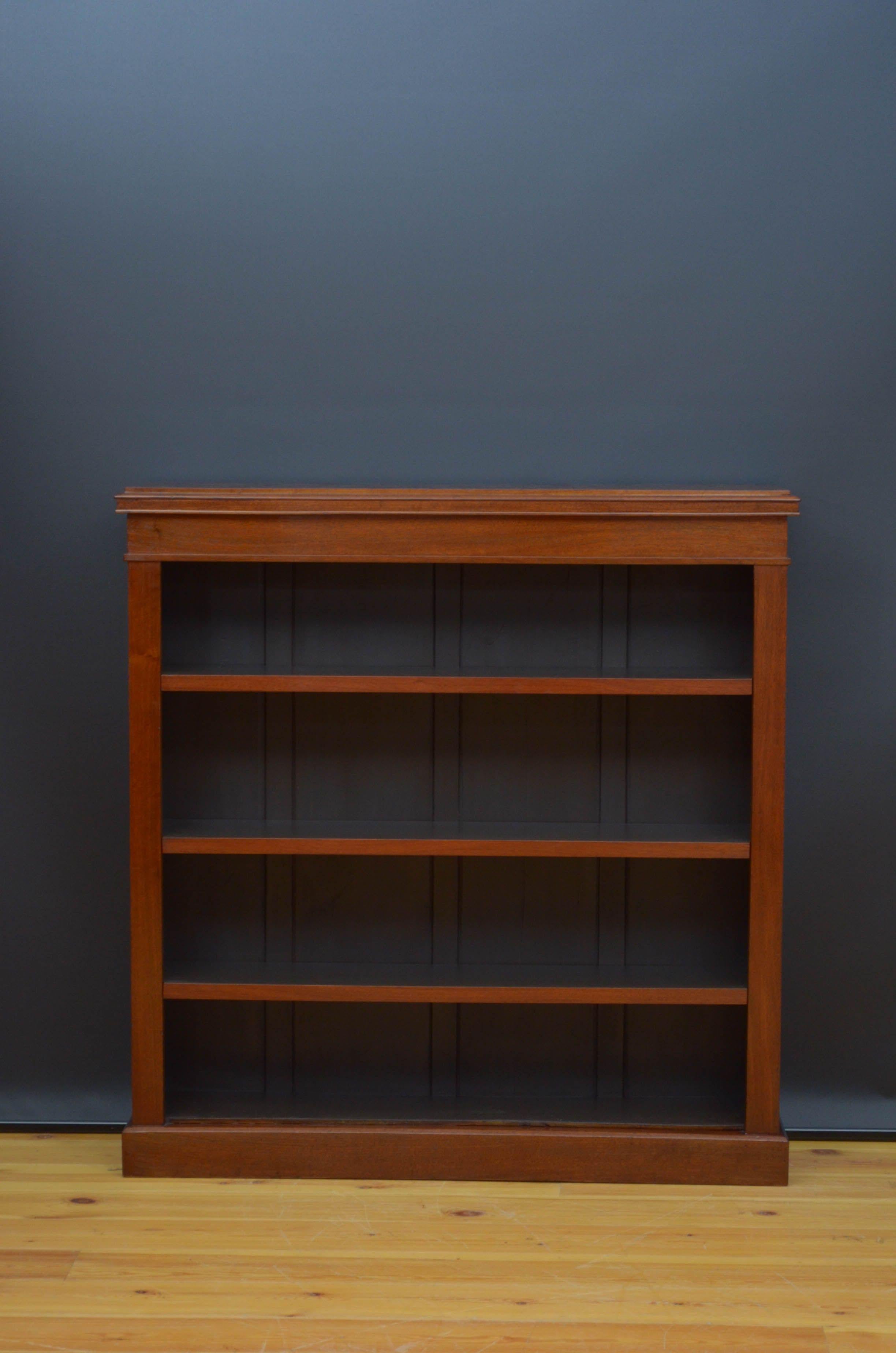 R04 Victorian open bookcase of simple and elegant design, having figured top with moulded edge above shallow frieze and three height adjustable shelves, all standing on moulded plinth base. This antique bookcase has been sympathetically restored and
