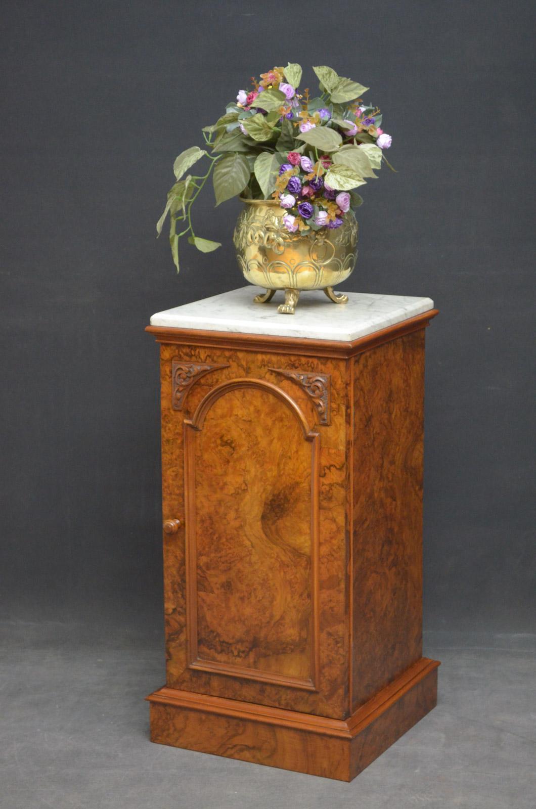 Sn4655, elegant Victorian walnut pedestal or bedside cabinet, having original marble top above panelled arched door with carved decoration, enclosing a shelf, fitted with original turned handle, all standing on plinth base. 
This unusual cabinet is