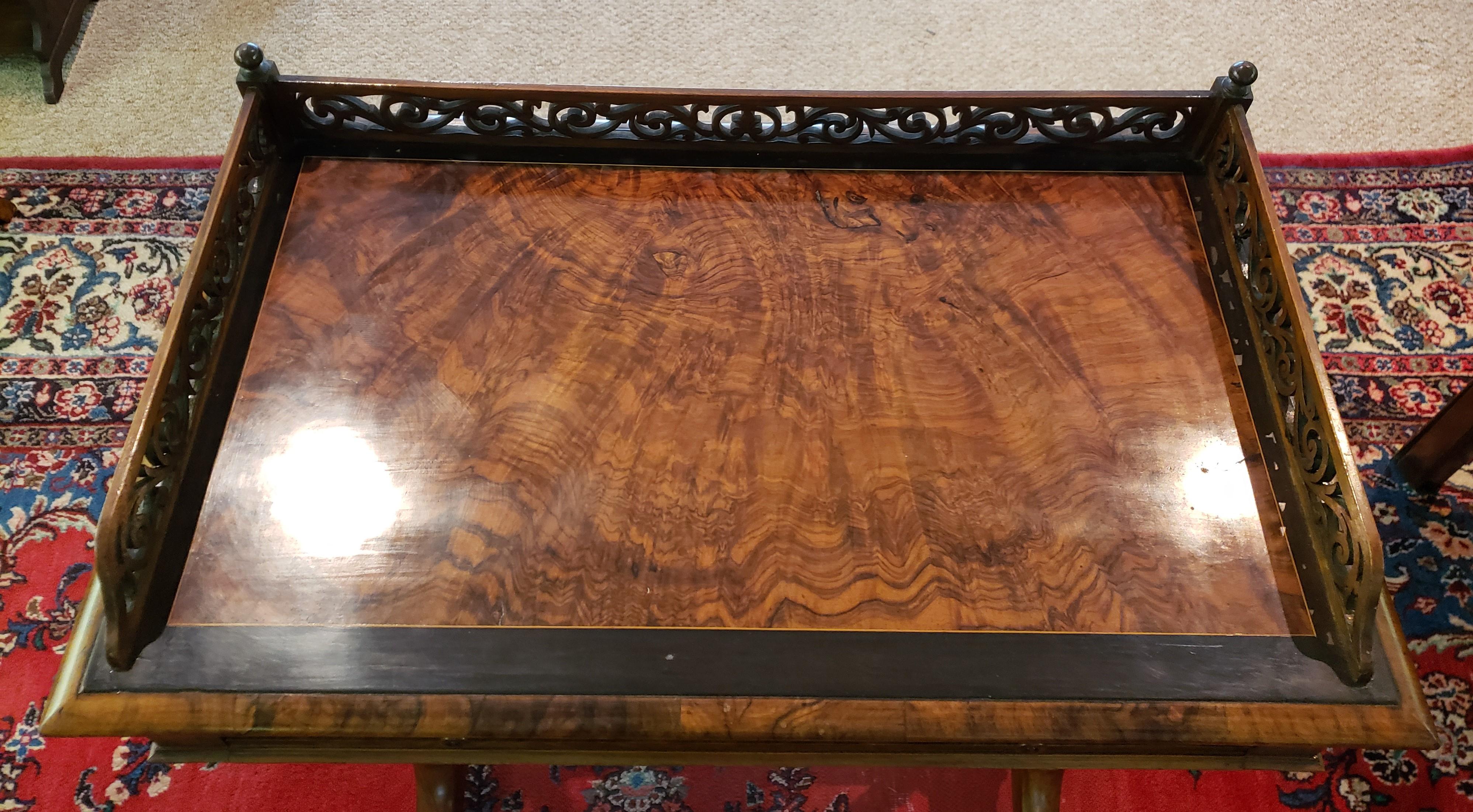 Victorian walnut sewing table featuring carved gallery, ebonized wood, and barley twist legs with castors on the feet.