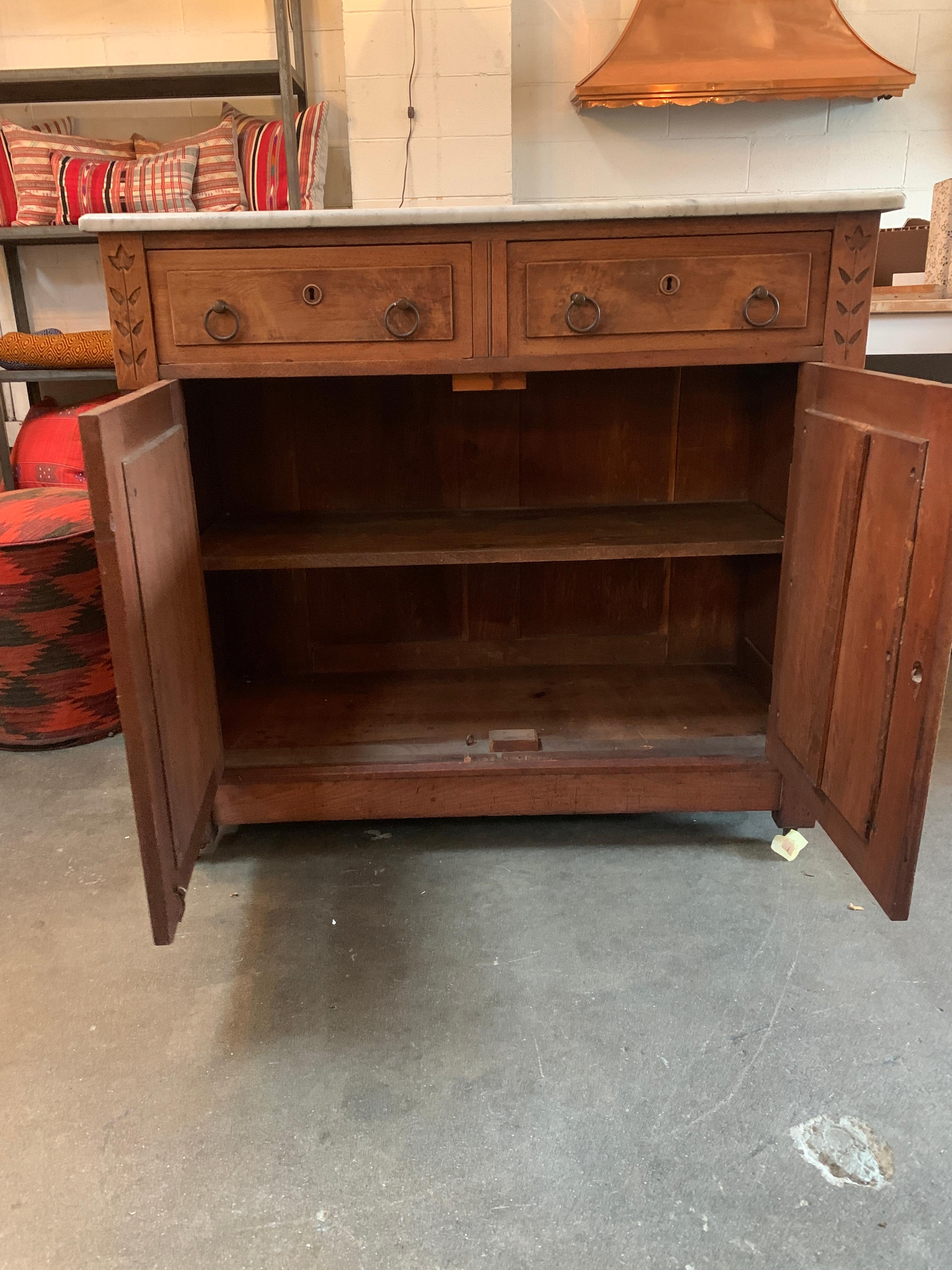 This Victorian walnut sideboard with a marble top is a beautiful piece by itself, but it also has a rich and interesting history. Documented in a type-written note with accompanying newspaper from 1959, this piece was once a part of the Phillips
