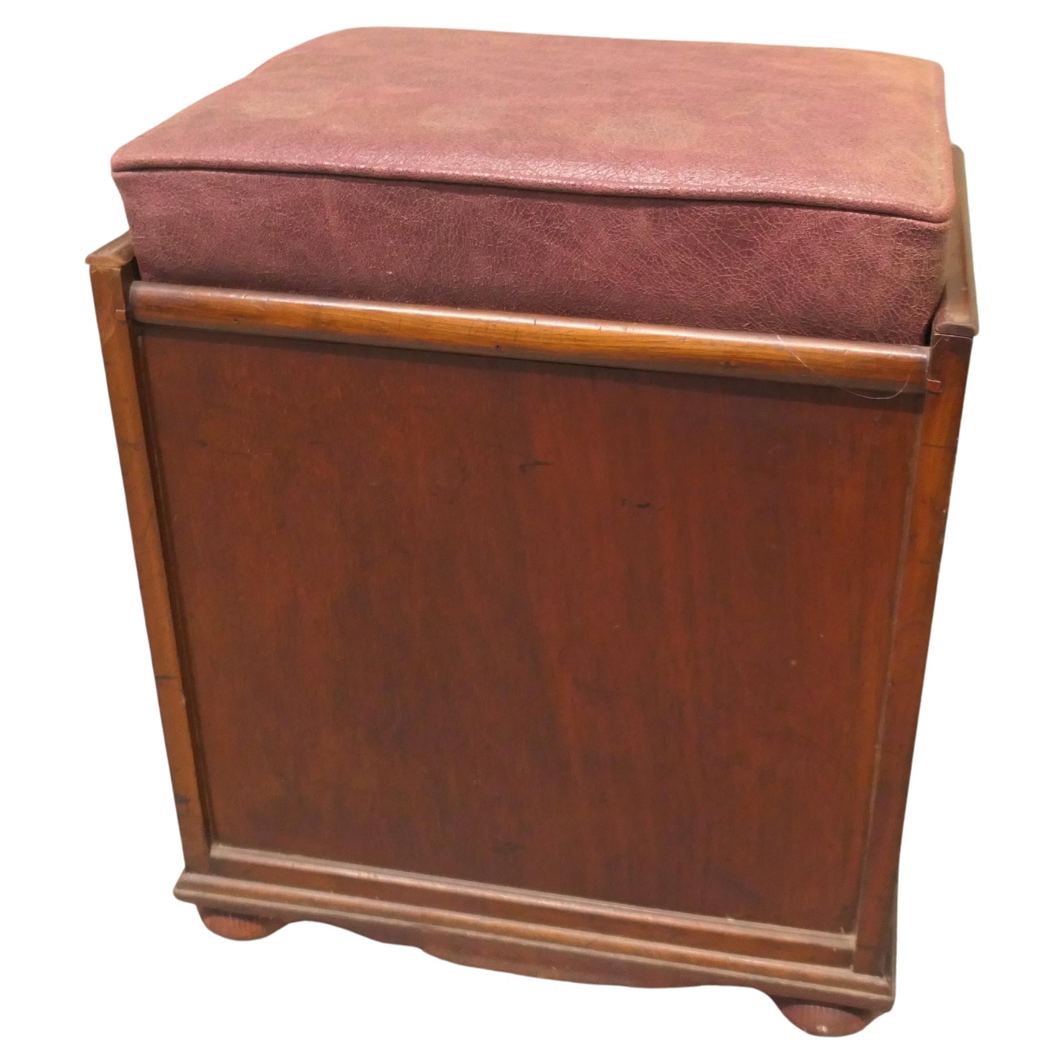 Tabouret de piano victorien en noyer tapissé

Le tabouret est de forme rectangulaire avec une façade tombante divisée en espaces de rangement pour les partitions.
Le tabouret est très robuste et recouvert de cuir. 

Le tabouret est en bon état de