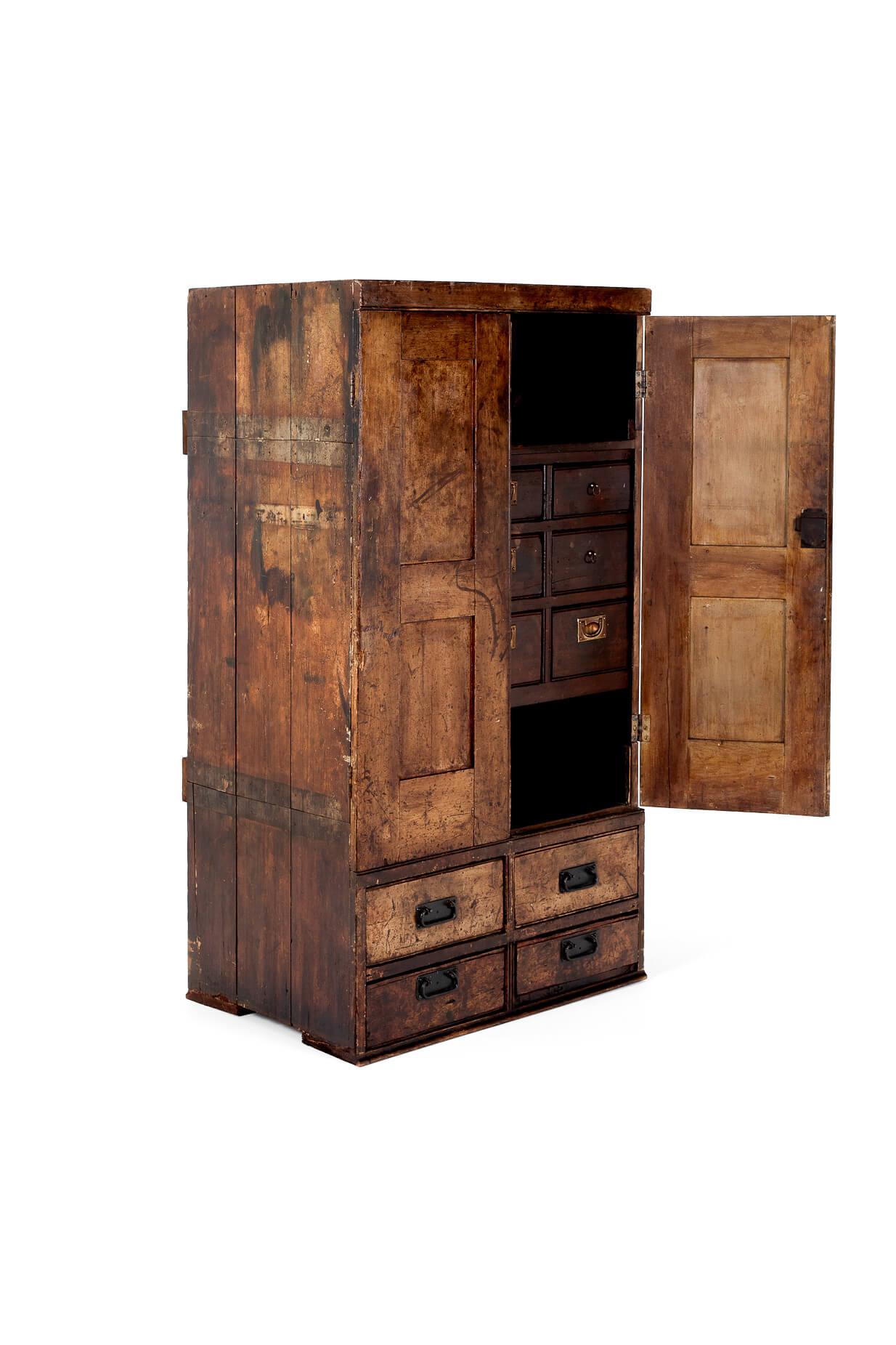 An oak watch makers cabinet from a family jewelry shop in the West Midlands that specialised in watch movements and repairs.

The top cupboard section has a pair of doors with original closing latches that open to a wide open shelf above a bank of