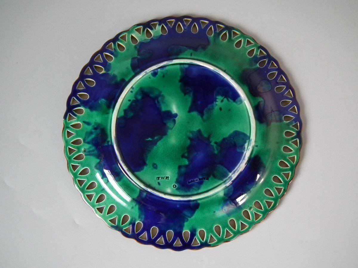 Wedgwood Majolica plate which features pheasants amongst foliage. Coloration: green, blue, ochre, are predominant. The piece bears maker's marks for the Wedgwood pottery. Marks include a factory specific date cipher for the year 1877.