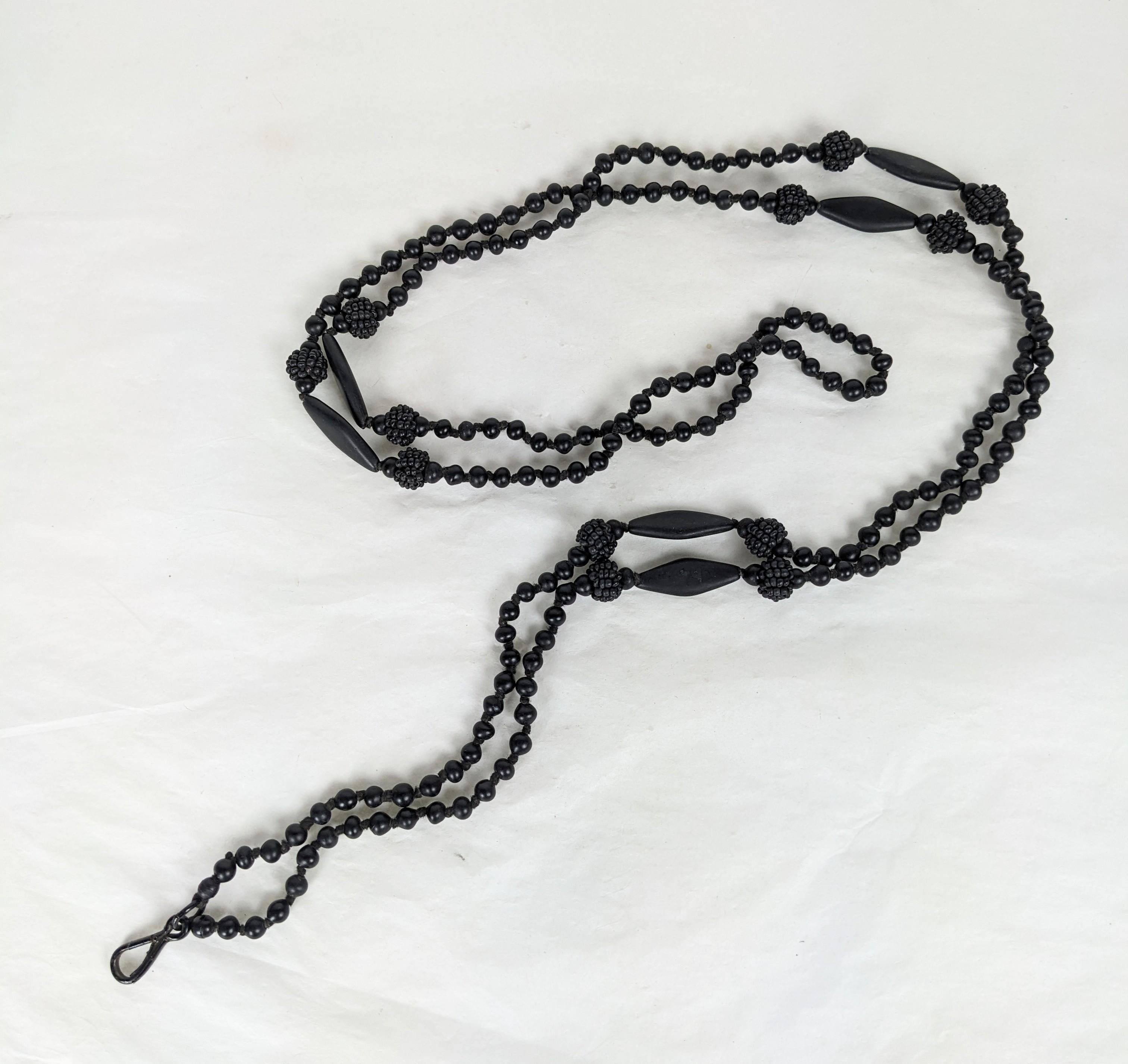 Victorian matt black Whitby Jet lorgnette bead necklace. Composed of small round hand knotted beads, six large elongated kite shape beads flanked by round beads of woven matt Whitby jet seed beads. With black enameled hook clasp. 1890's. 
Very Good