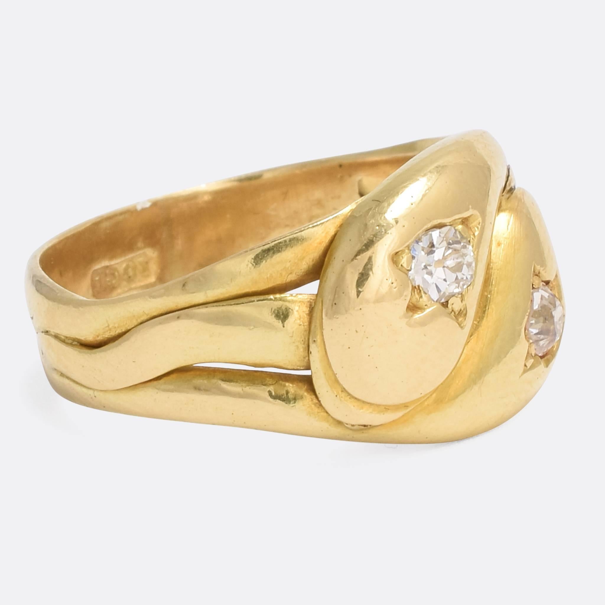A particularly style Victorian double snake ring, each serpent set with an old mine cut diamond in the head. It's modelled in a rich 18k yellow gold, with stylize 