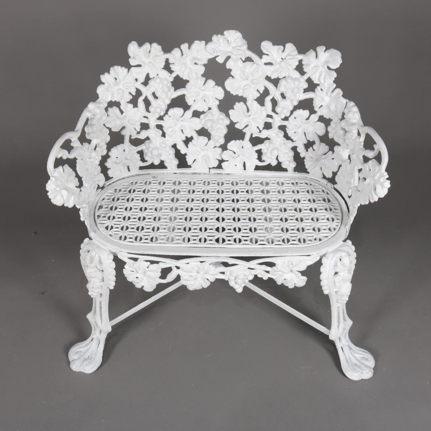 Victorian reticulated garden bench features cast iron construction in grape and leaf pattern and seated on cabriole legs terminating in stylized paw feet garden table, painted white, 20th century.


Measures: 27