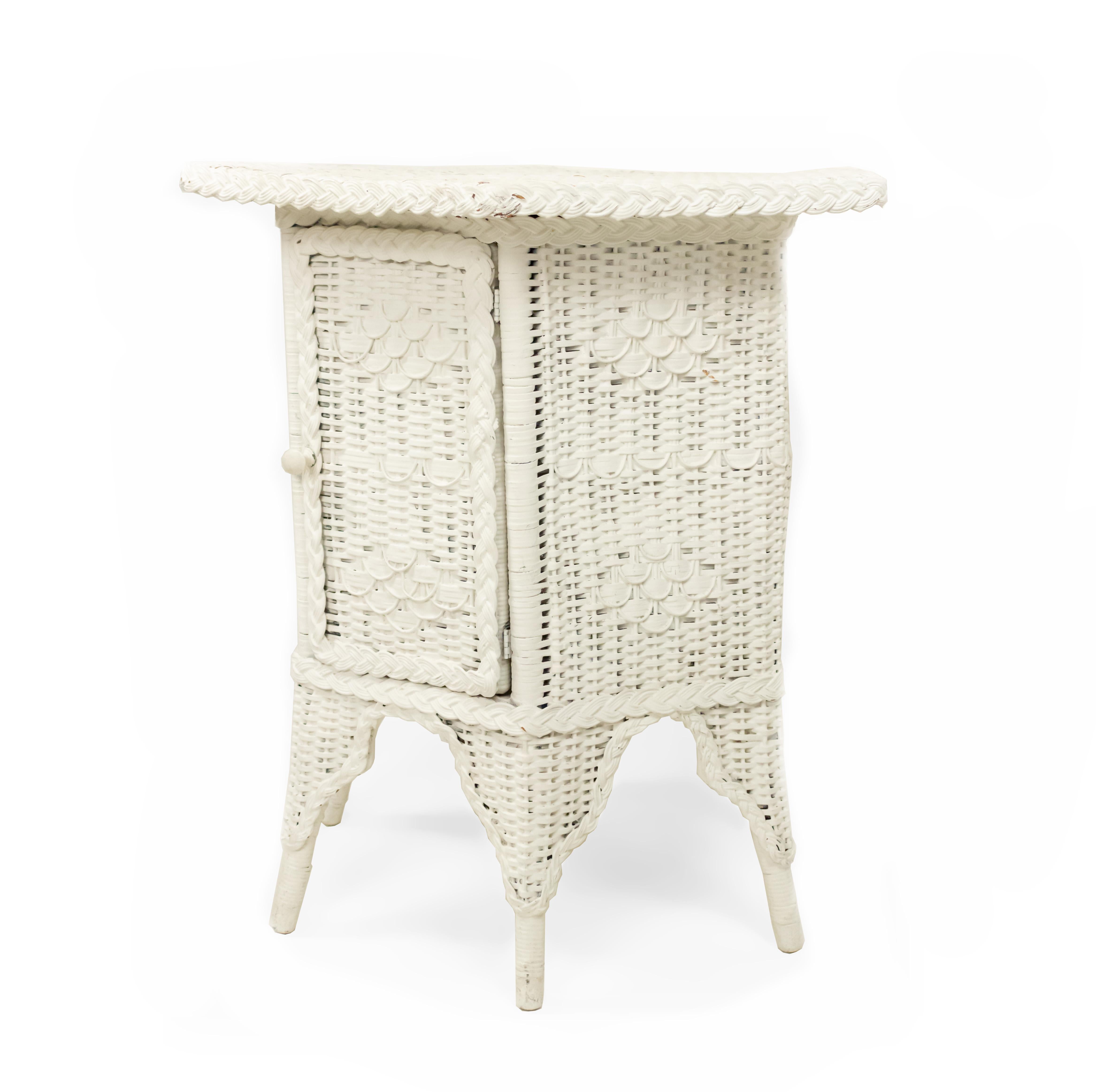 American Victorian white painted woven wicker large end table with 6-sided top and having a door on base.