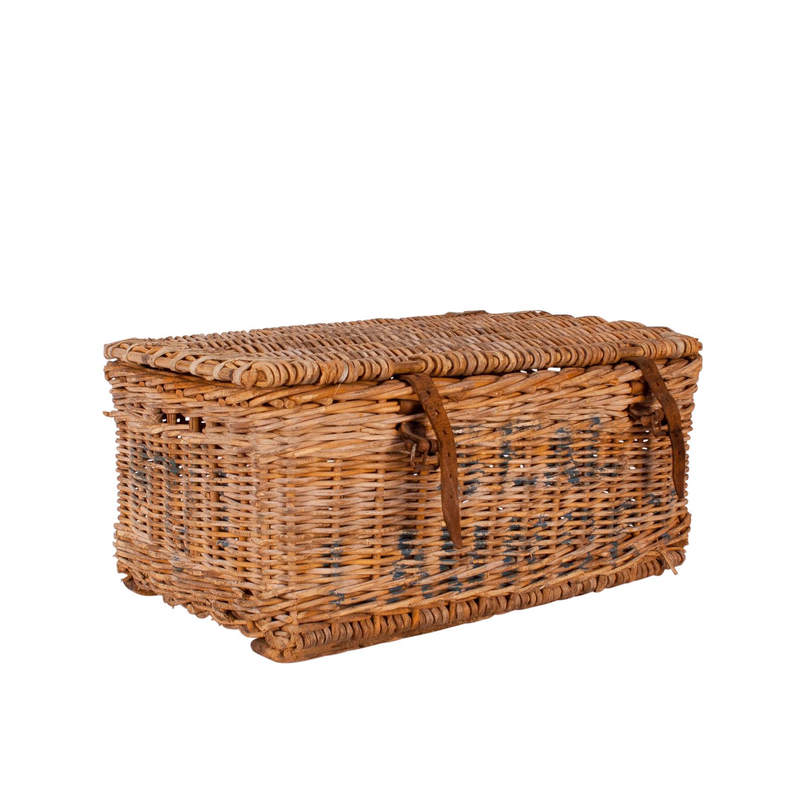 An early 20th century English wicker basket with leather straps, circa 1900.