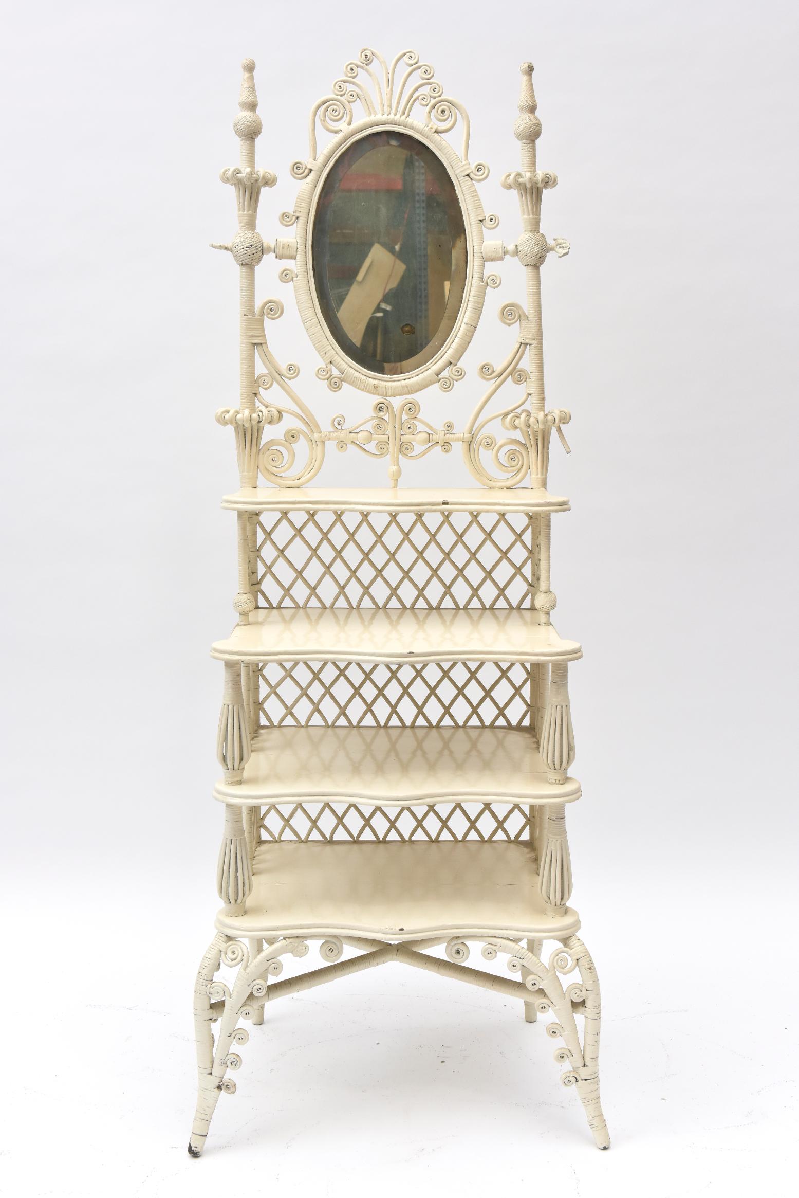 Part of a Senator's wife's wicker collection, this shaving or vanity mirror with display shelves is a very rare piece. Almost every element of Victorian wicker is used here: open lattice work, curlicues, woven wood beads, birdcage spacers on shelf