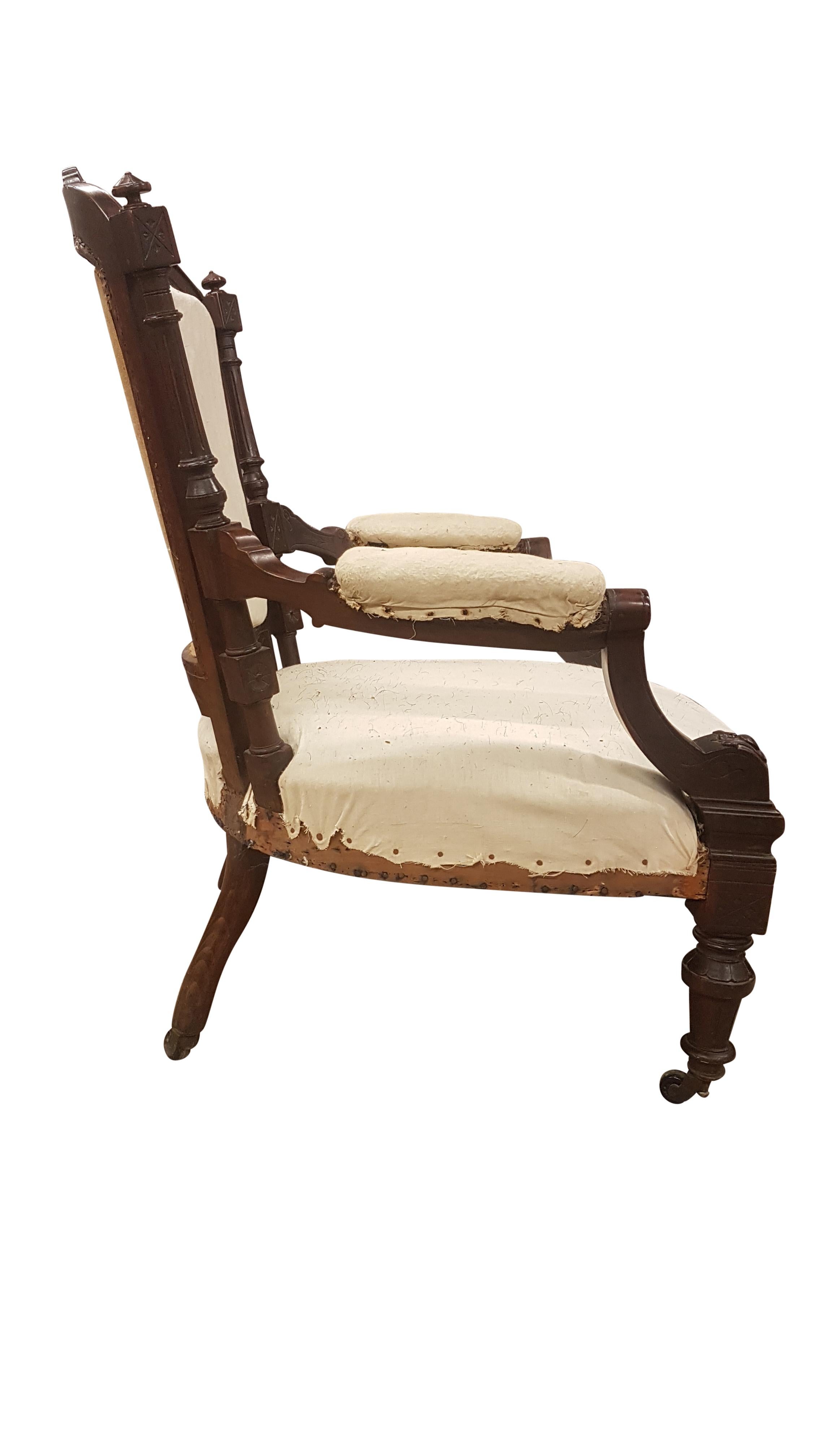 An ornately carved and turned solid rosewood open armchair with an unusually wide seat. The chair has had the upholstery taken back to it's calico lining, all springs and padding are in very good order and ready for recovering. The rosewood carvings