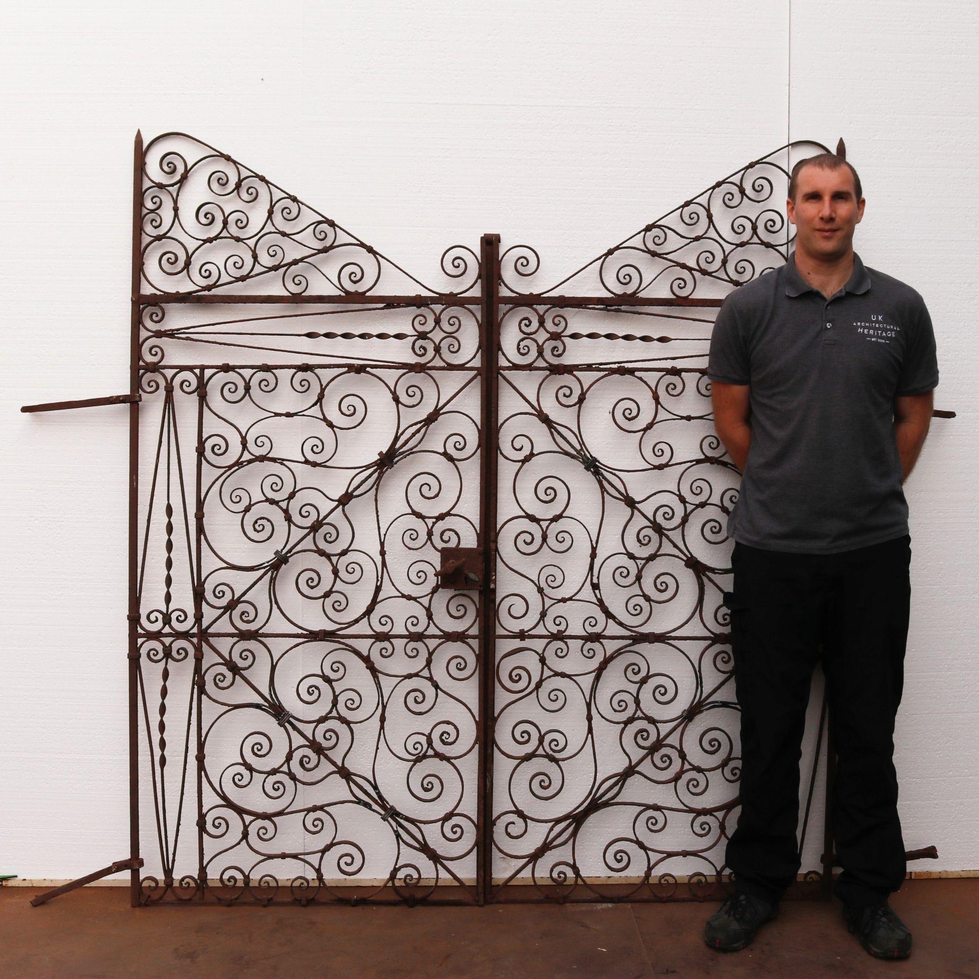 Victorian wrought iron French pedestrian gates. Dating back to 1870, this pair incorporate both Victorian and Regency styles alike, which would fit well in the garden of an English countryside home or period property. The abundance of scrolls morph