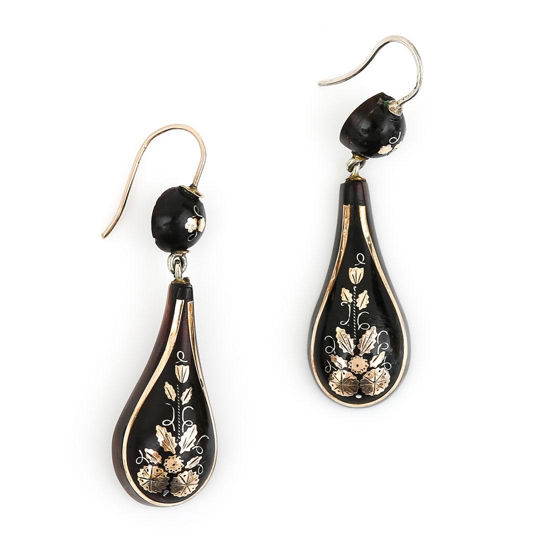 A unique pair of Victorian yellow gold and silver inlay pique earrings hand crafted in circa 1870. The elongated teardrop shaped pique drops, beautifully inlaid with stylised floral and geometric circle patterns formed of gold and silver.