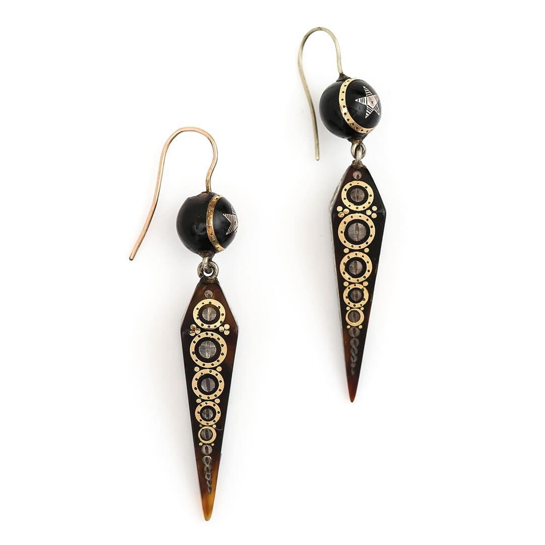 A delightful pair of Victorian yellow gold and silver inlay pique earrings hand crafted in circa 1870. The tapered obelisk shaped pique drops, beautifully inlaid with stylised geometric circle patterns formed of gold and silver. Maintaining their