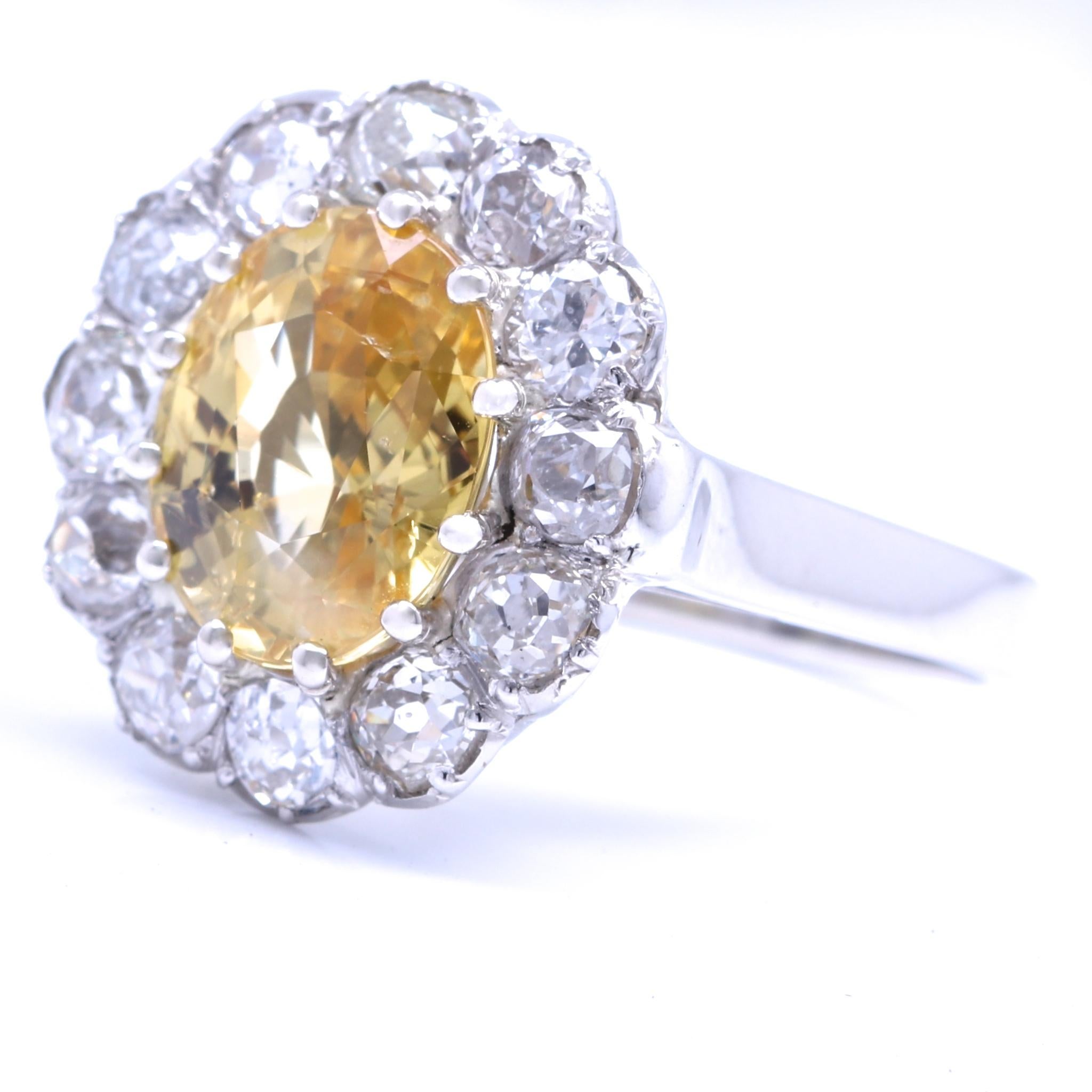 There is nothing as captivating as a beautiful yellow sapphire, surrounded by shimmering white diamonds. This is a very well preserved Victorian cluster ring which features a 4.45 carat yellow sapphire. The sapphire is surrounded by 12 old European