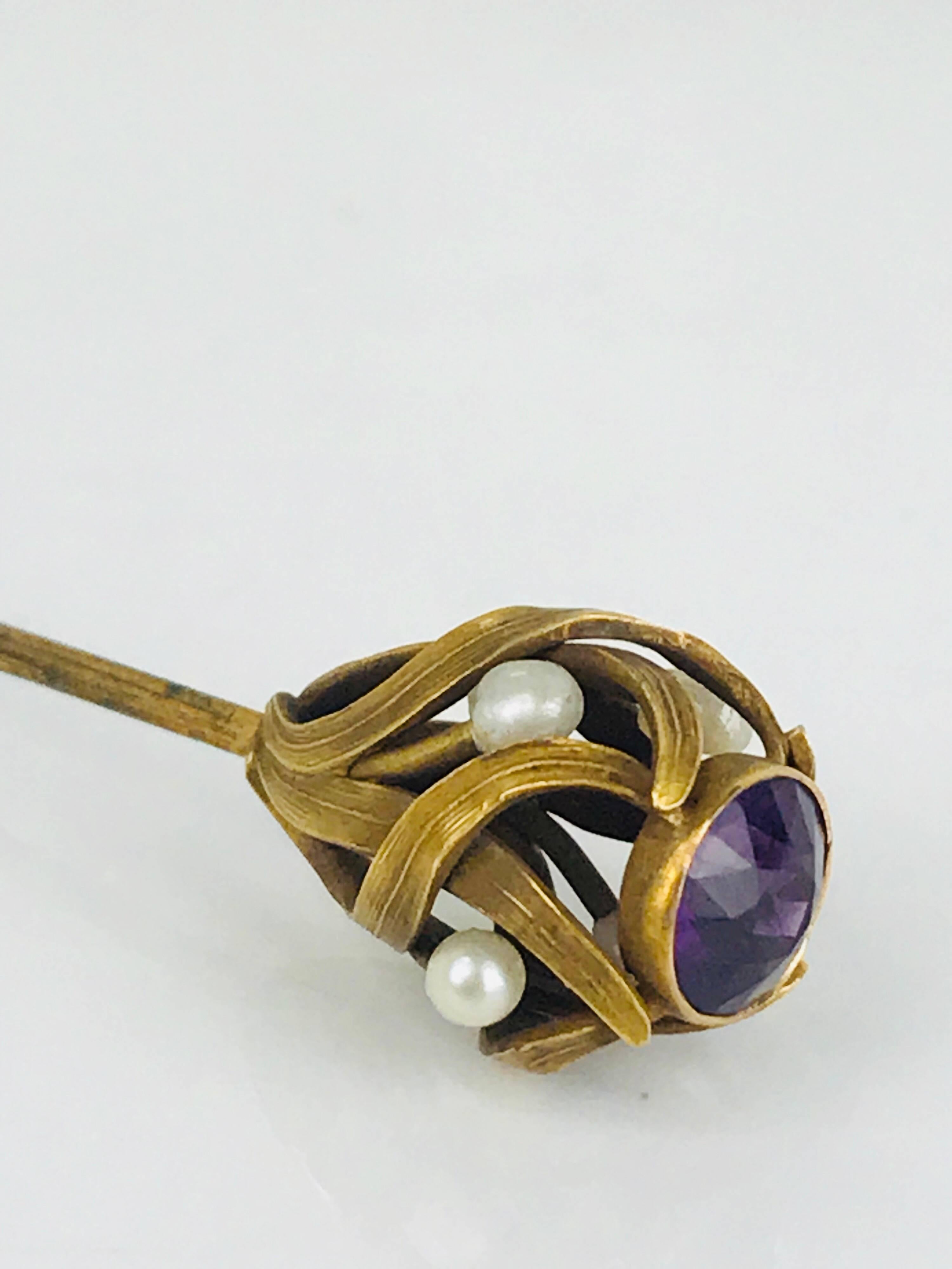 Victorian, 14 Karat Gold, Seed Pearl and Old Mine-Cut Amethyst Hat Pin, Circa 1840, features a bezel-set, round brilliant, old mine cut natural amethyst stone set at the top of the pinhead, and is accented by 4 seed pearls and graceful openwork