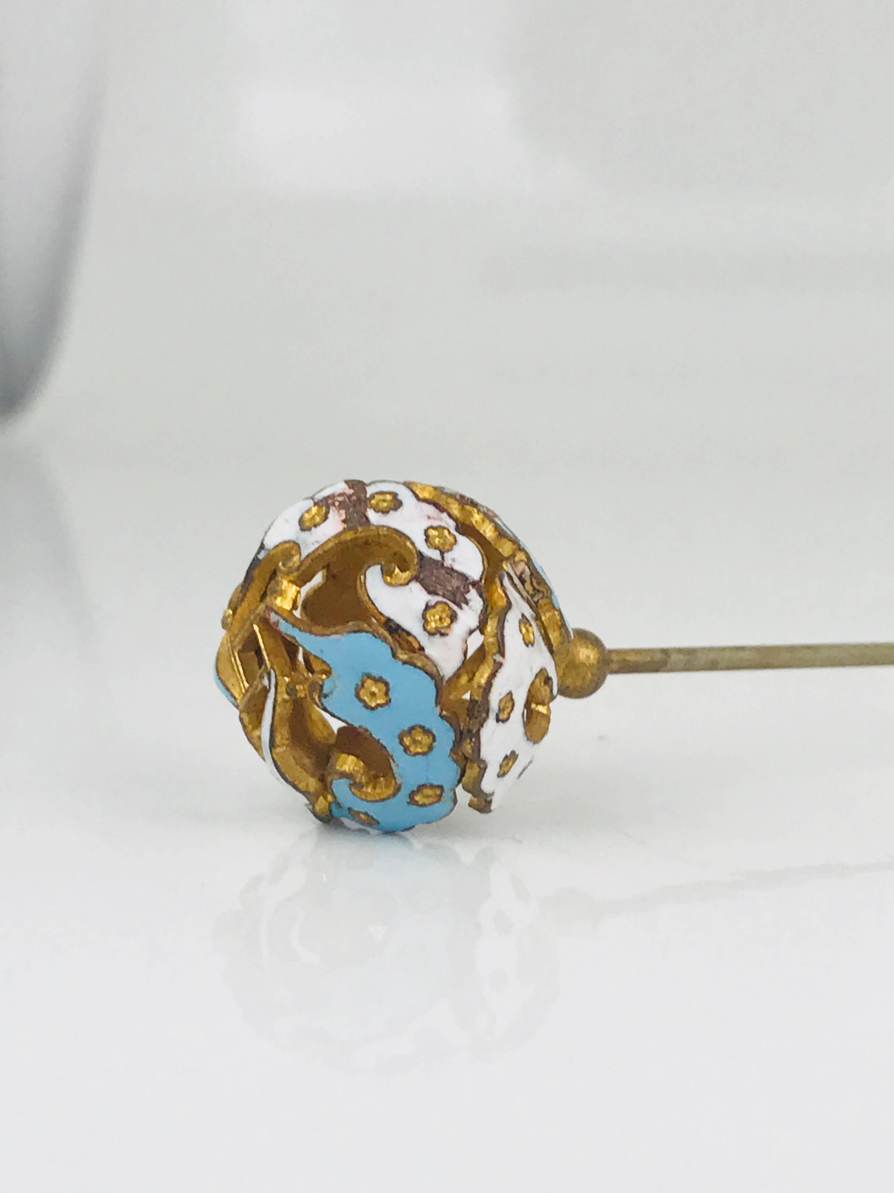 Victorian, Circa 1870 Hat Pin features a decorative, openwork head.  The decorative head is round vermeil, and covered in tiny raised flowers.  The background is enameled in white & turquoise colored enamel.

Hat pin measures 8.60