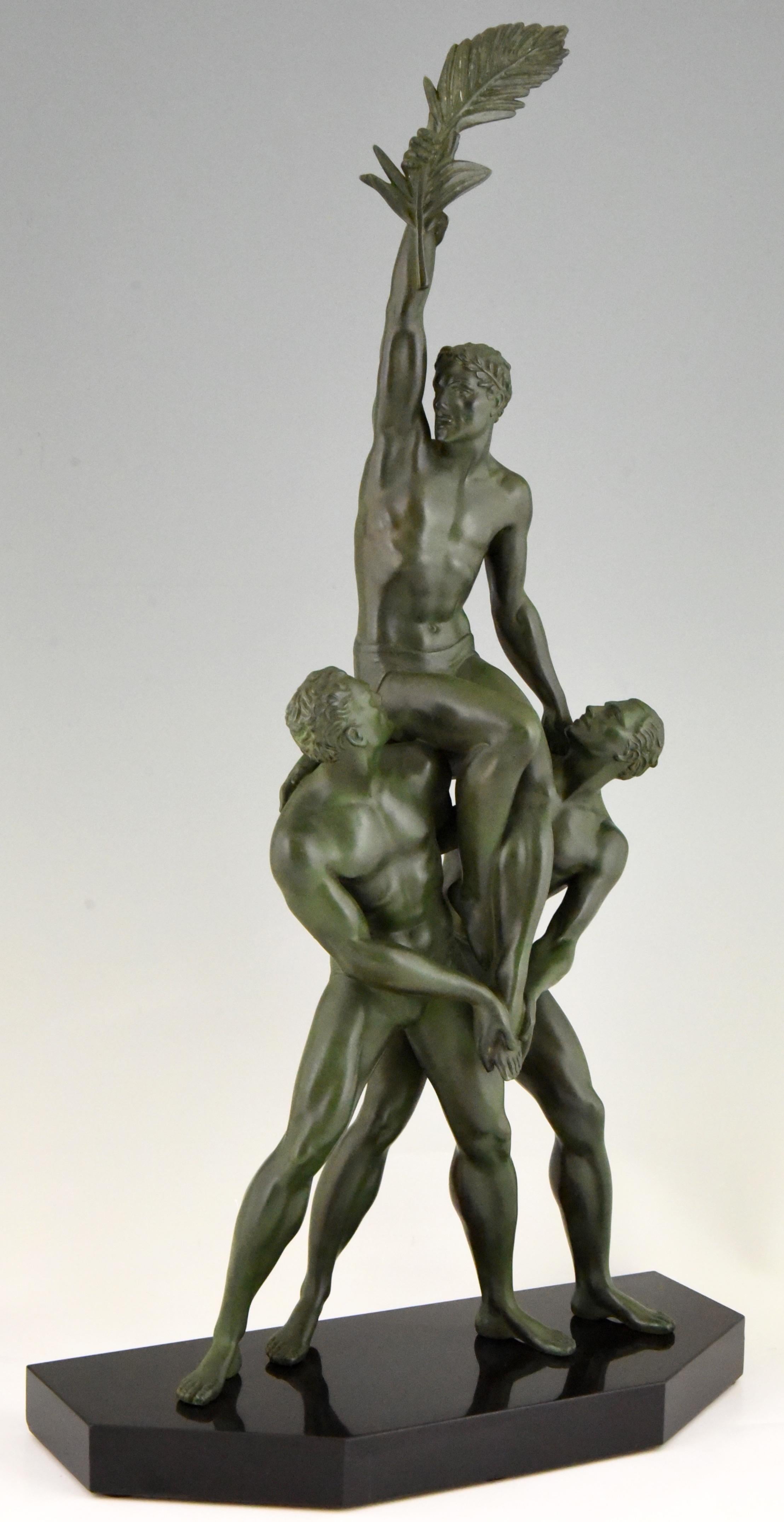 Victory, impressive Art Deco sculpture of three athletic men by the well known French sculptor Pierre Le Faguays. The man in the middle is sitting on the shoulders of the other two and holds a palm leaf in his outstreched arm as a sign of