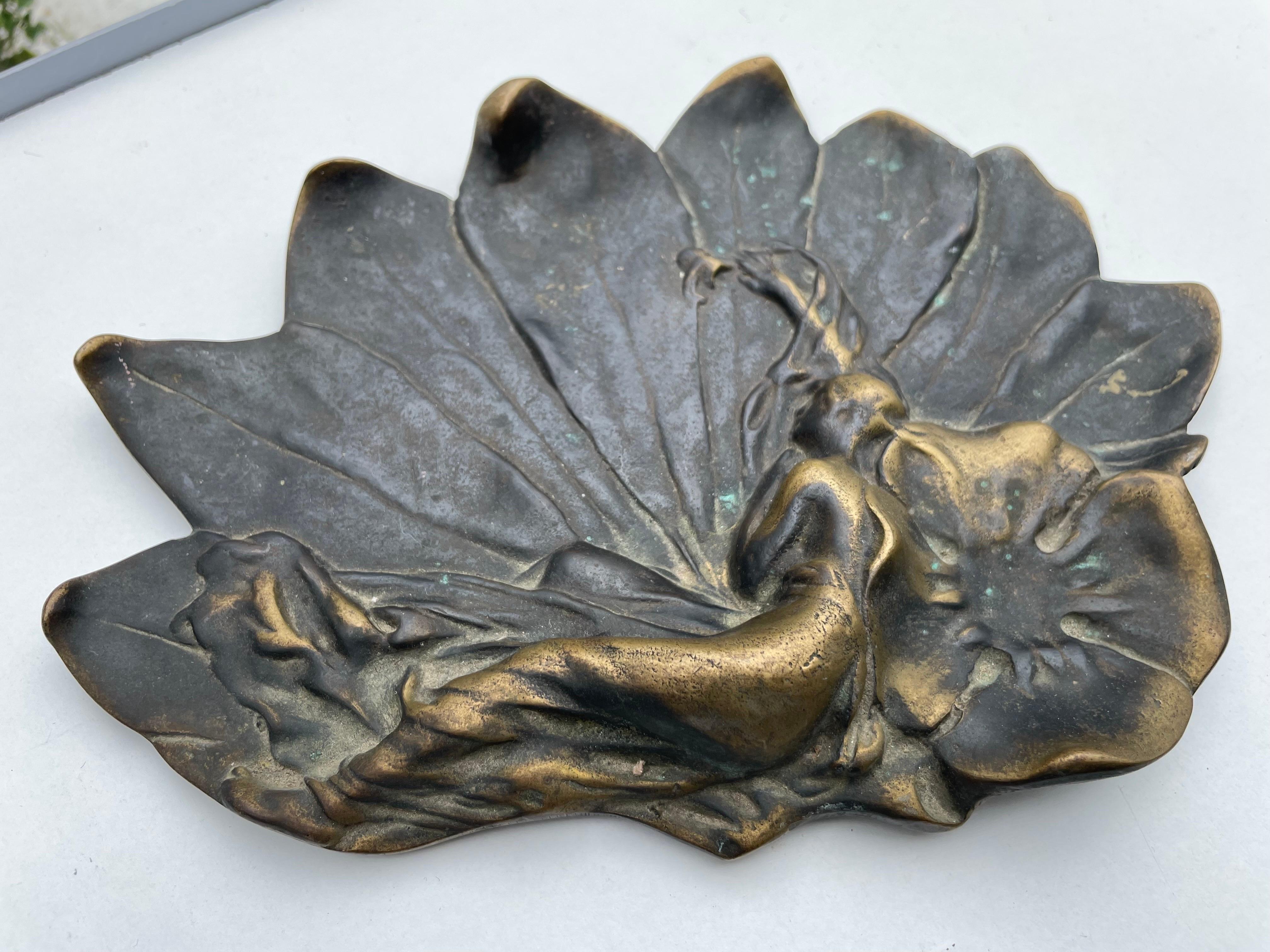 This vide poche is from the Art Nouveau period. It is in bronze, the reclining woman is in gold color, and the rest of the item is in a brown/ black patina.
It has been made in france circa 1920.
 