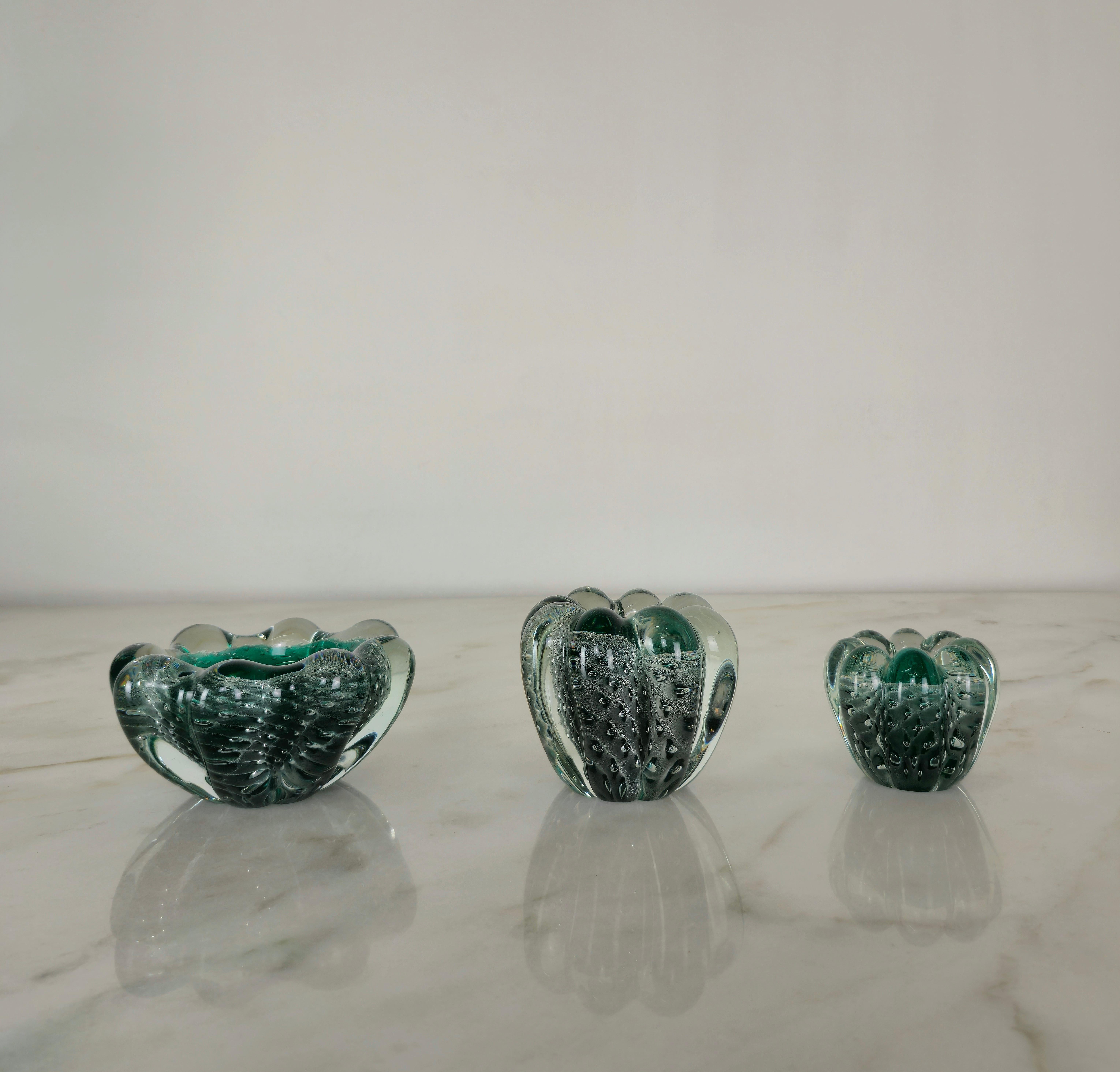 Ensemble de 3 vide-poche/cendriers/objets décoratifs de différentes tailles produits en Italie dans les années 1950 par Seguso Vetri d'Arte.
Les 3 objets ont été réalisés en verre de Murano sommerso bullicante dans des tons transparents et vert