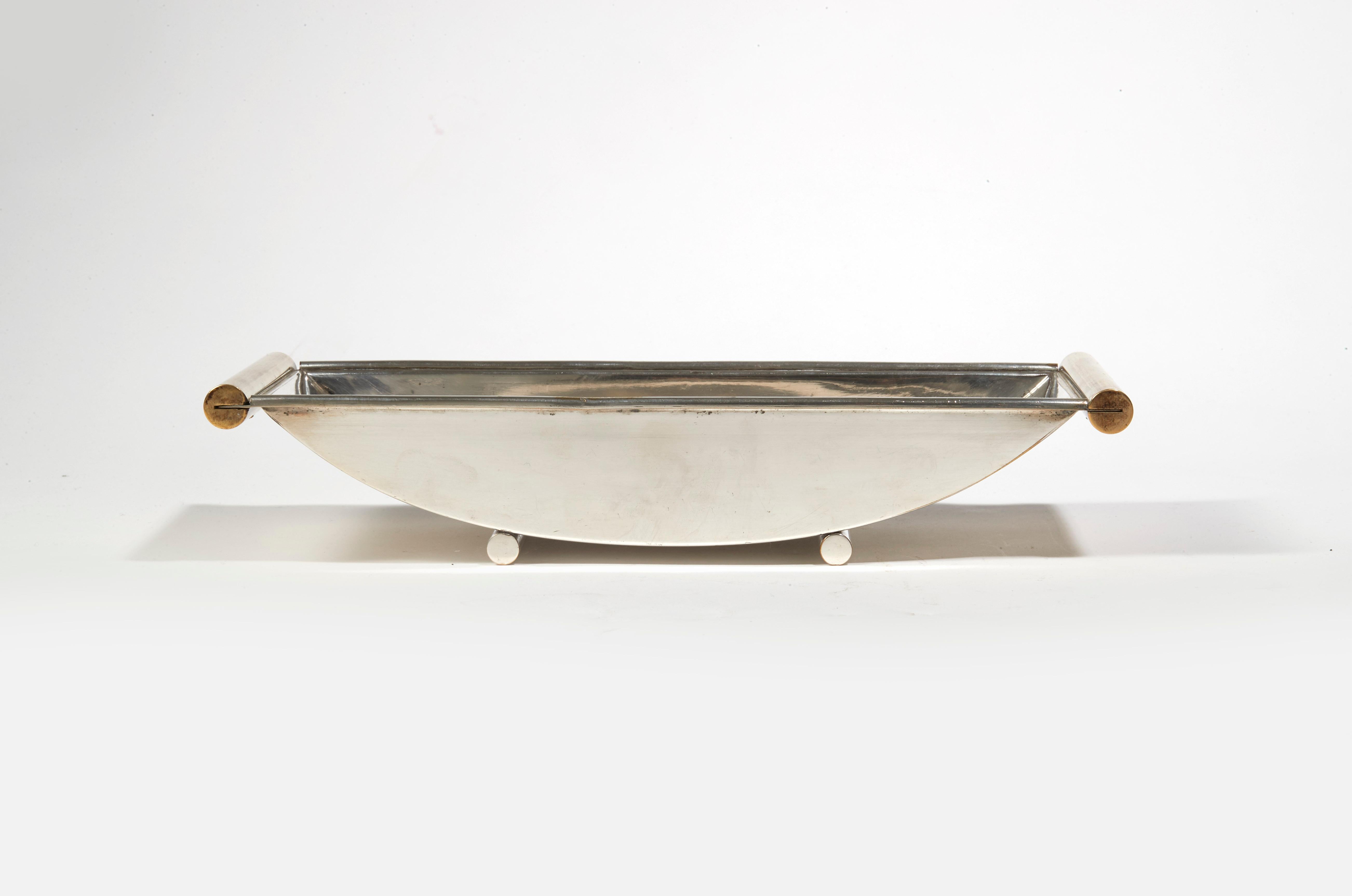 Bowl in silver nickel-plated metal, with two tubular bars as legs and wooden tubular handles. Underside stamped with 