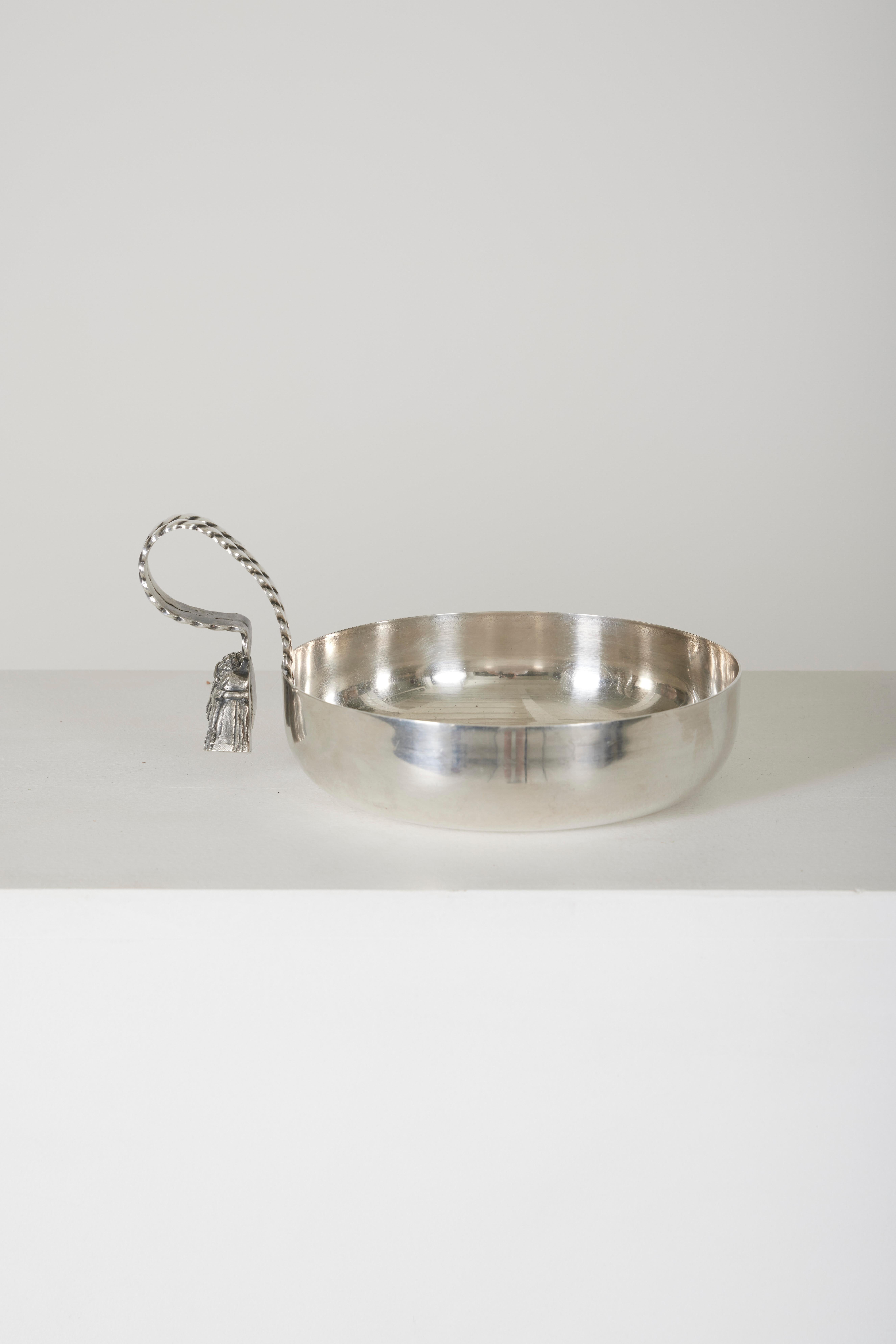 Vide poche designed by Maria Pergay in the 50s/60s. Pocket bowl in silver metal, handle decorated with a bracelet ending in two pompoms, border also decorated with a bracelet. Very good condition.
LP1105