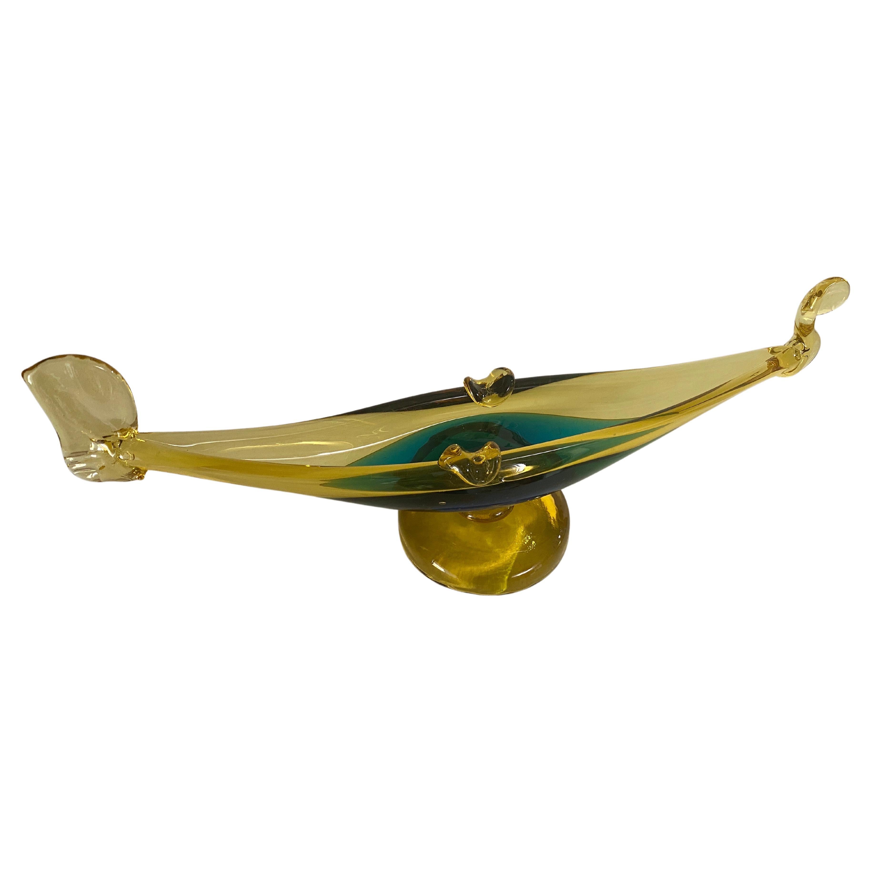 This vide poche or ashtray in in Glass. It has been done circa 1970, in Murano, Italy..
The shape is a Venice Gandola.
Transparent yellow  and Green Color.