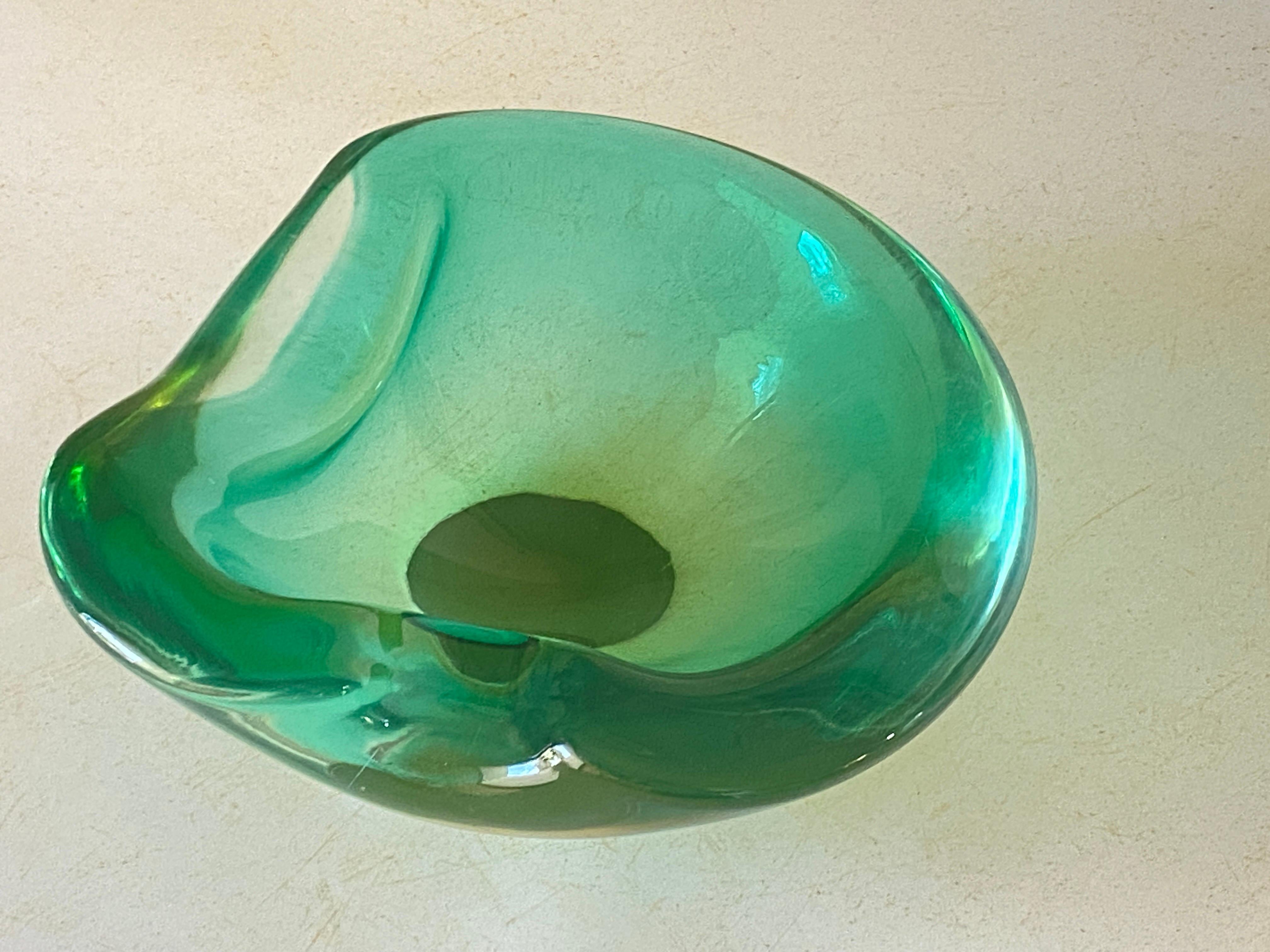 This vide poche or ashtray in in Glass. It has been done circa 1970, in Murano, Italy..
The shape is a free form.
Transparent yellow  and Green Color.
