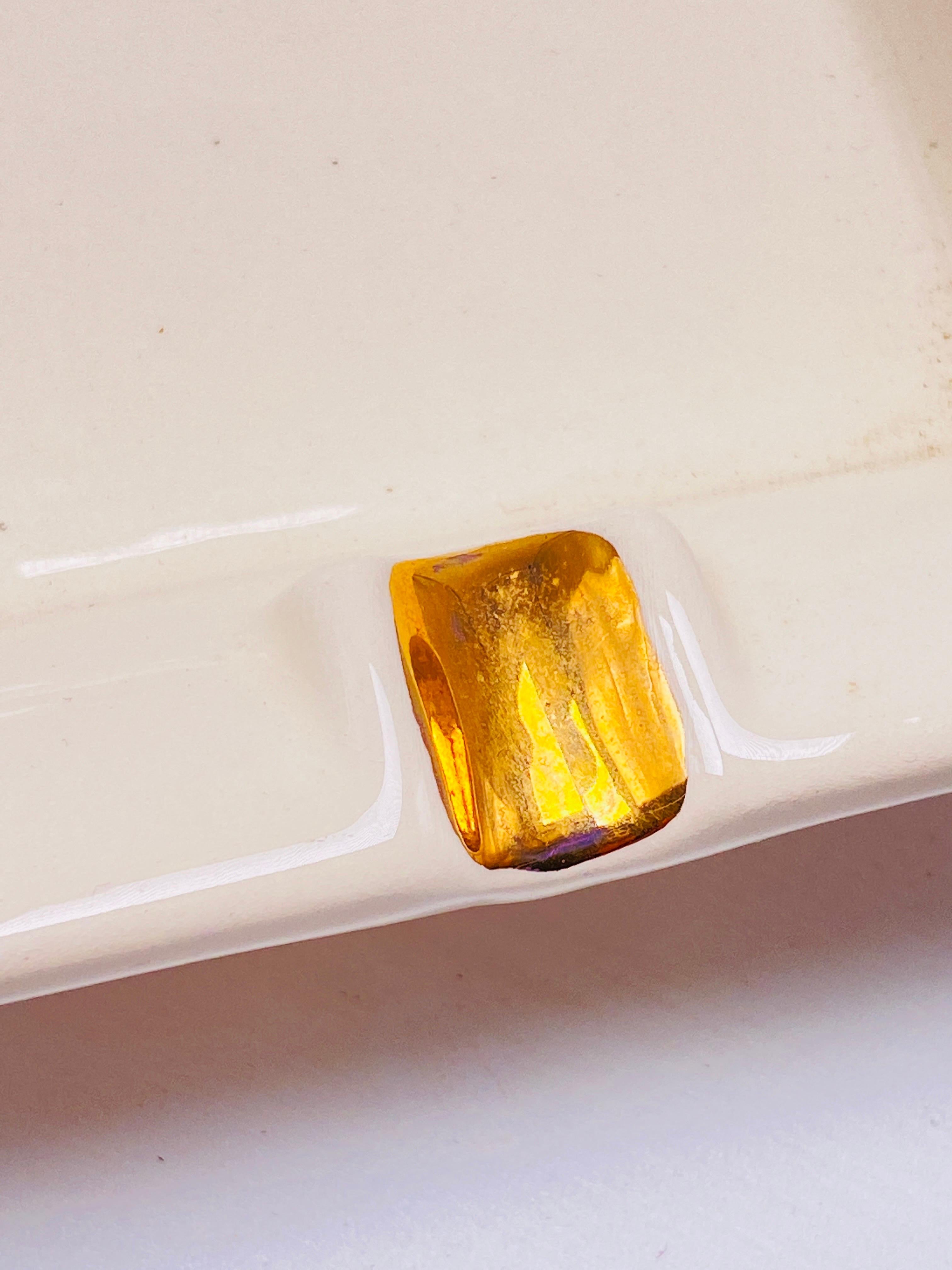 Ce vide-poche est en porcelaine. Il est de couleur blanche et a été fabriqué en France dans les années 1970 et 1980. Les côtés ont été dorés à la feuille d'or.