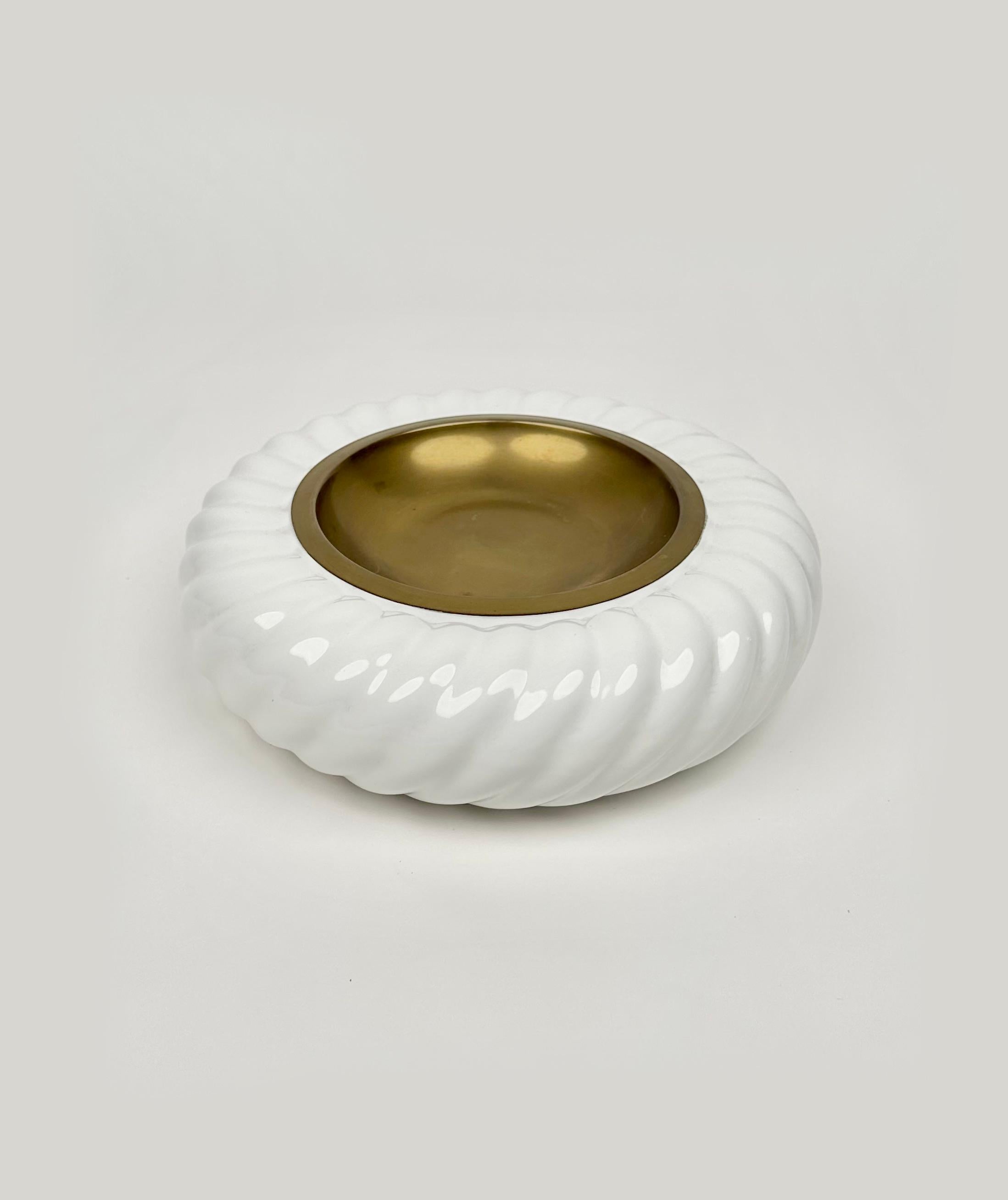Superbe cendrier rond ou vide-poche en céramique blanche et laiton du designer italien Tommaso Barbi pour B ceramiche.   

Fabriqué en Italie dans les années 1970.   

La signature de Tommaso Barbi est visible sur le fond, comme le montrent les
