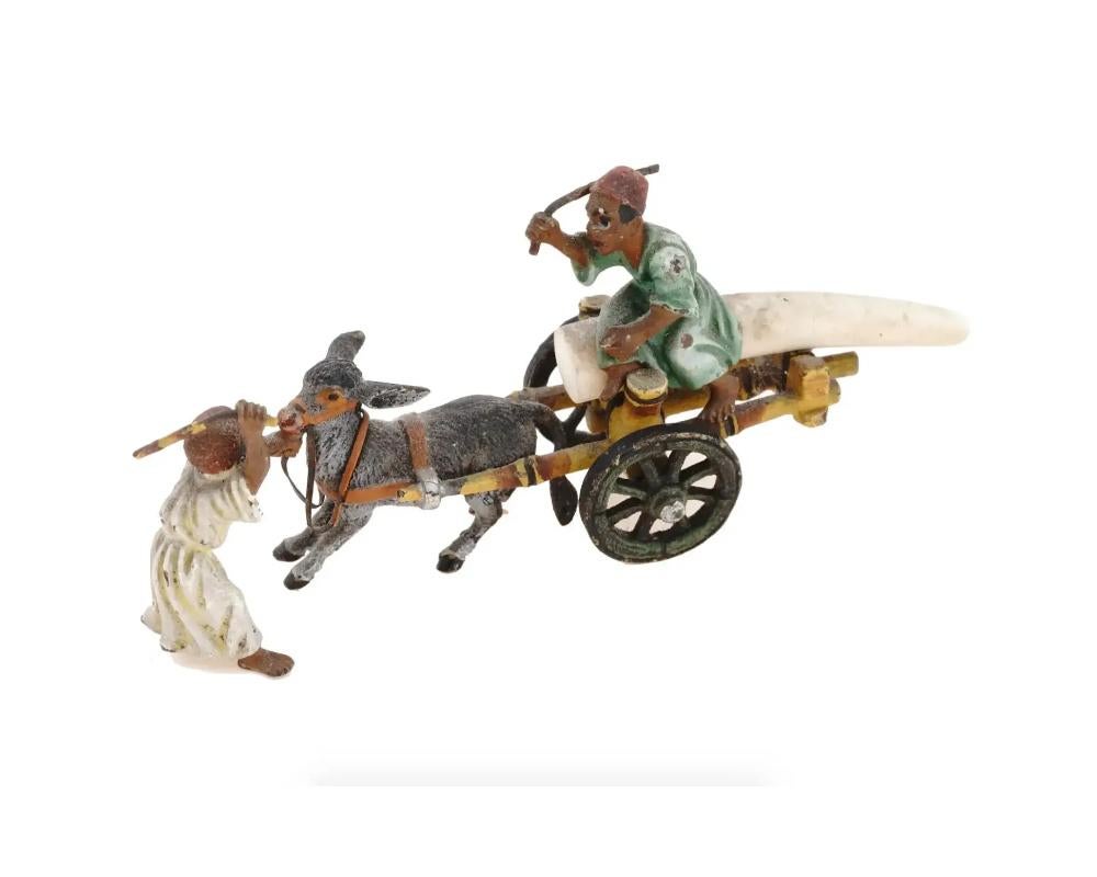 Groupe de figurines en bronze coulé peint à froid et matériaux naturels, de style oriental viennois. Le groupe figuratif représente une scène avec deux garçons arabes qui se disputent, l'un d'eux étant assis sur un chariot tiré par un âne. Réalisé à