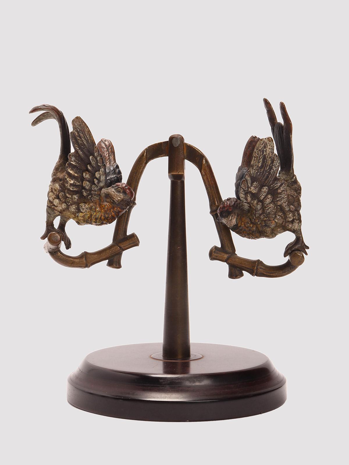 Wiener Bronzeskulptur, die eine Schaukel mit zwei Papageien darstellt, montiert auf einem runden Galalithsockel. Die beiden Papageien sind in verschiedenen Farben gemalt. Arbeitsbewegung. Wien Österreich um 1890.