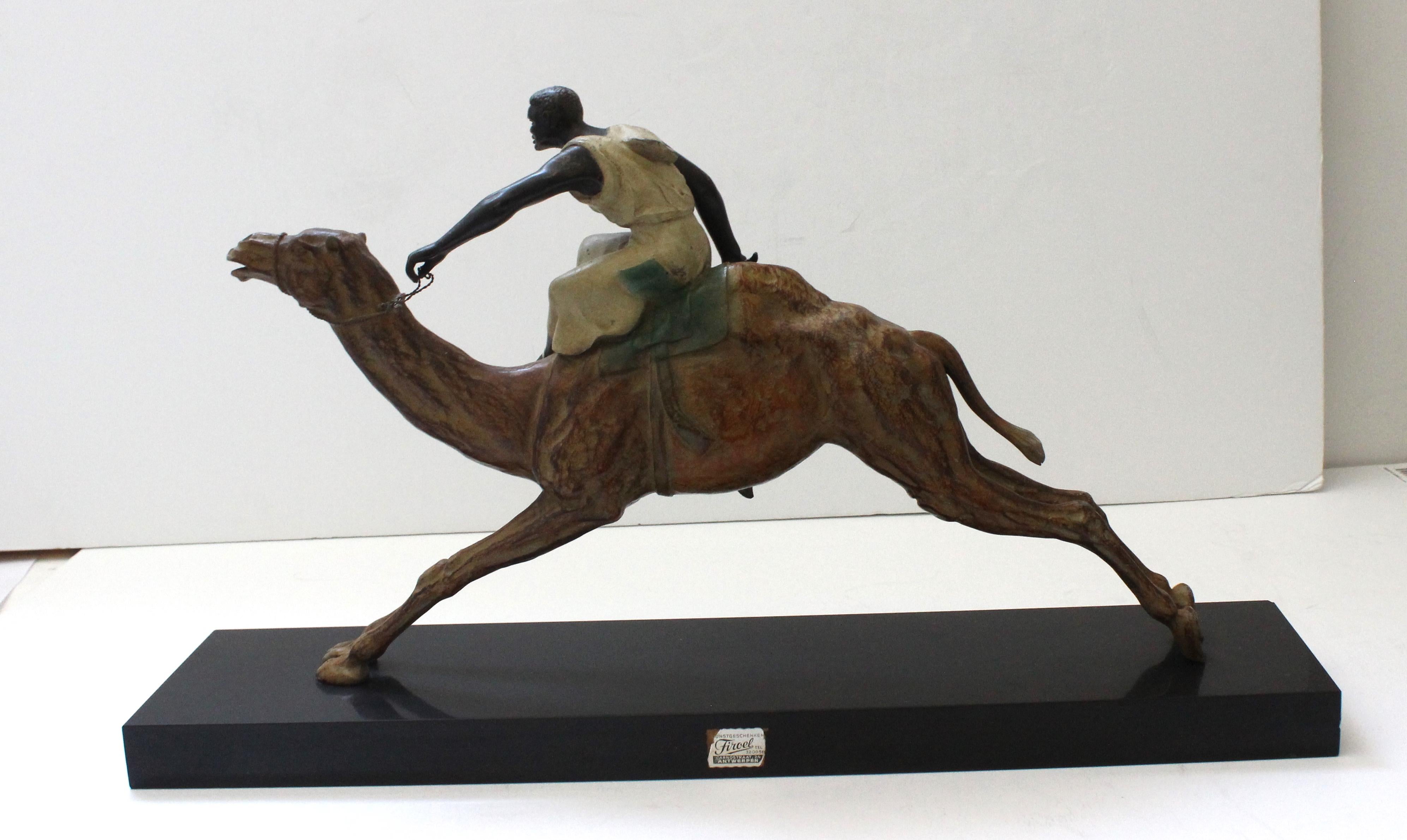 This large scale Viennese style figure of a camel and rider dates to the 1920s and 1930s, and the piece is fabricated in a hand painted, base-metal, and a black granite base. The piece is reminiscent of the Viennese, cold-painted bronzes so popular