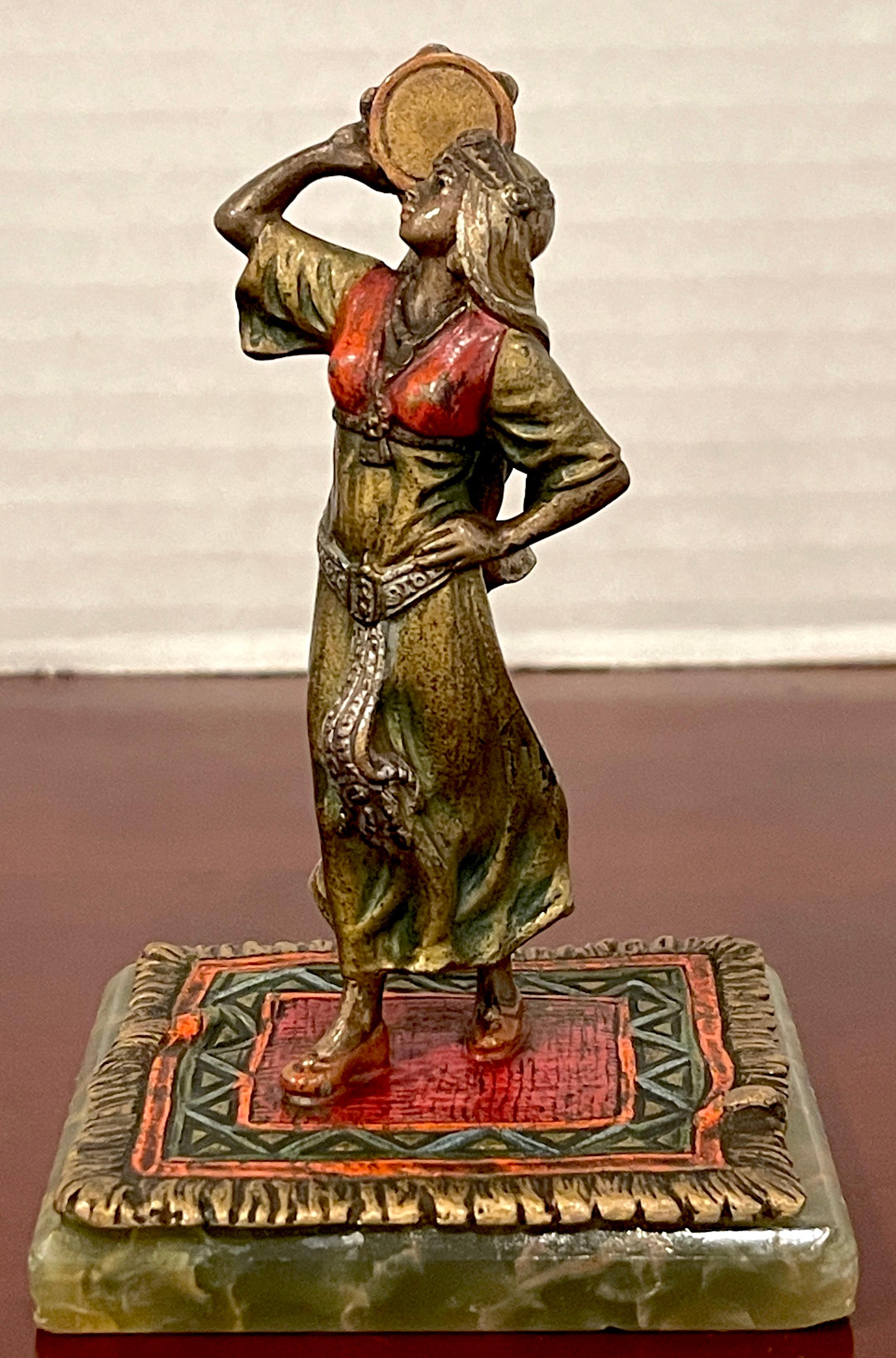 Vienna cold painted bronze 'Carmen' attributed to Bergman, Brilliantly enameled, of a gypsy girl with tambourine standing on a oriental rug, mounted on a conforming green onyx base.