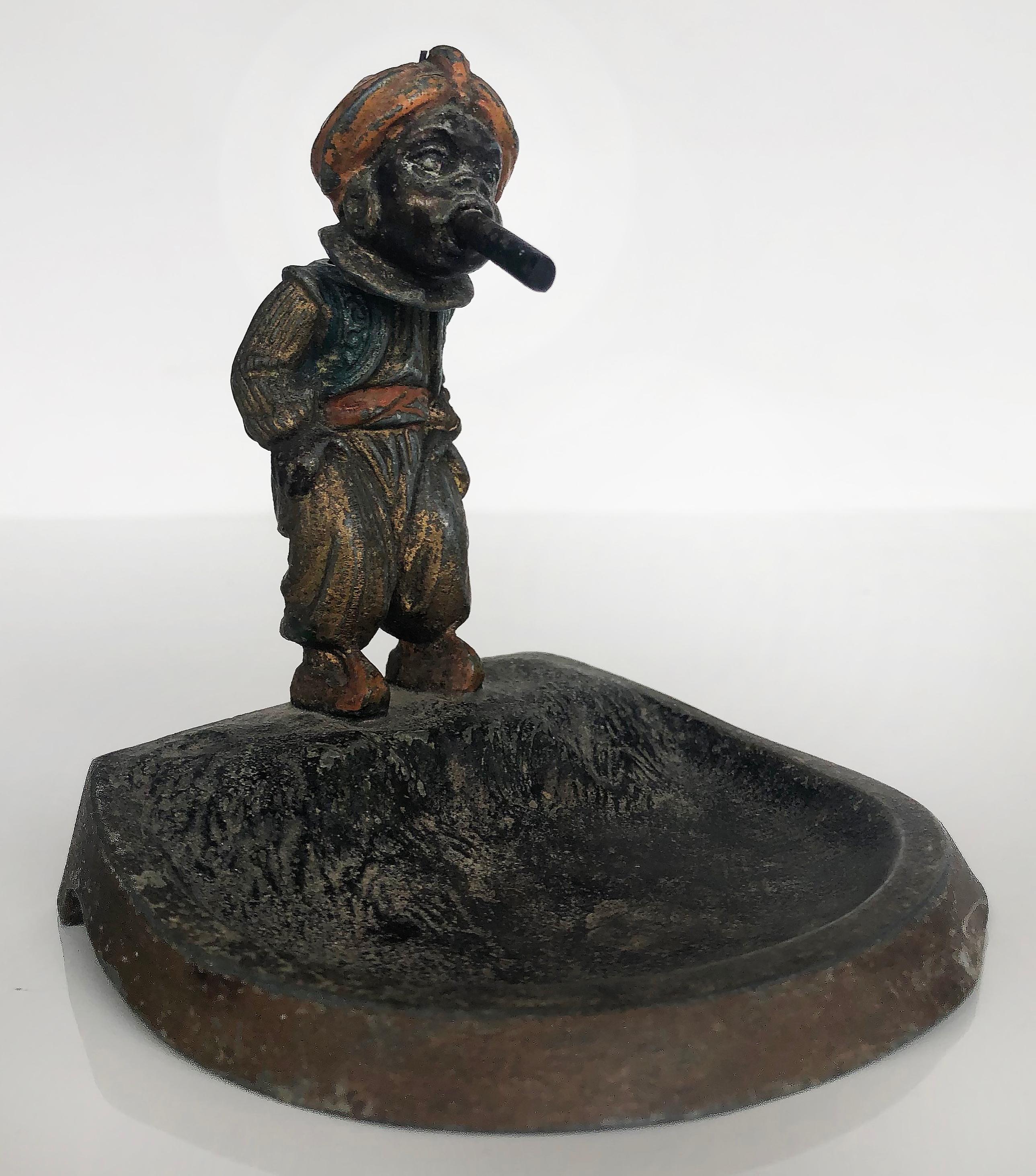 Vienna cold-painted orientalist bronze bobbing head man and opium pipe ashtray

Offered is a Vienna cold-painted Orientalist bronze of a man with a bobbing head smoking an opium pipe. This figurative sculpture is fashioned as an ashtray.