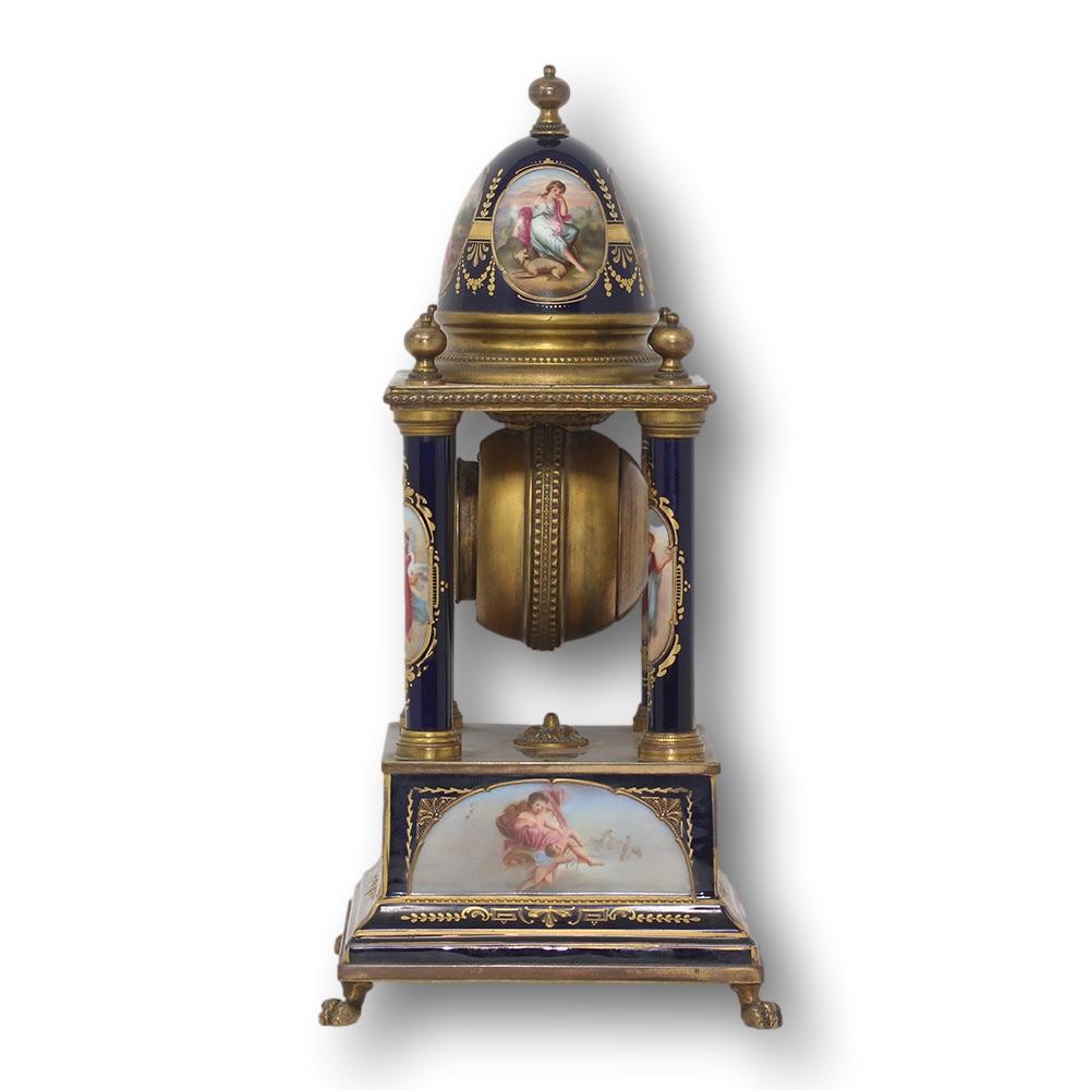 Pendule à colonne en porcelaine émaillée autrichienne de la fin du XIXe siècle, du studio Franz Dorfl. La pendule est de forme oblongue, avec un sommet bombé doté d'un fleuron en laiton menant à de multiples figures classiques à l'intérieur de