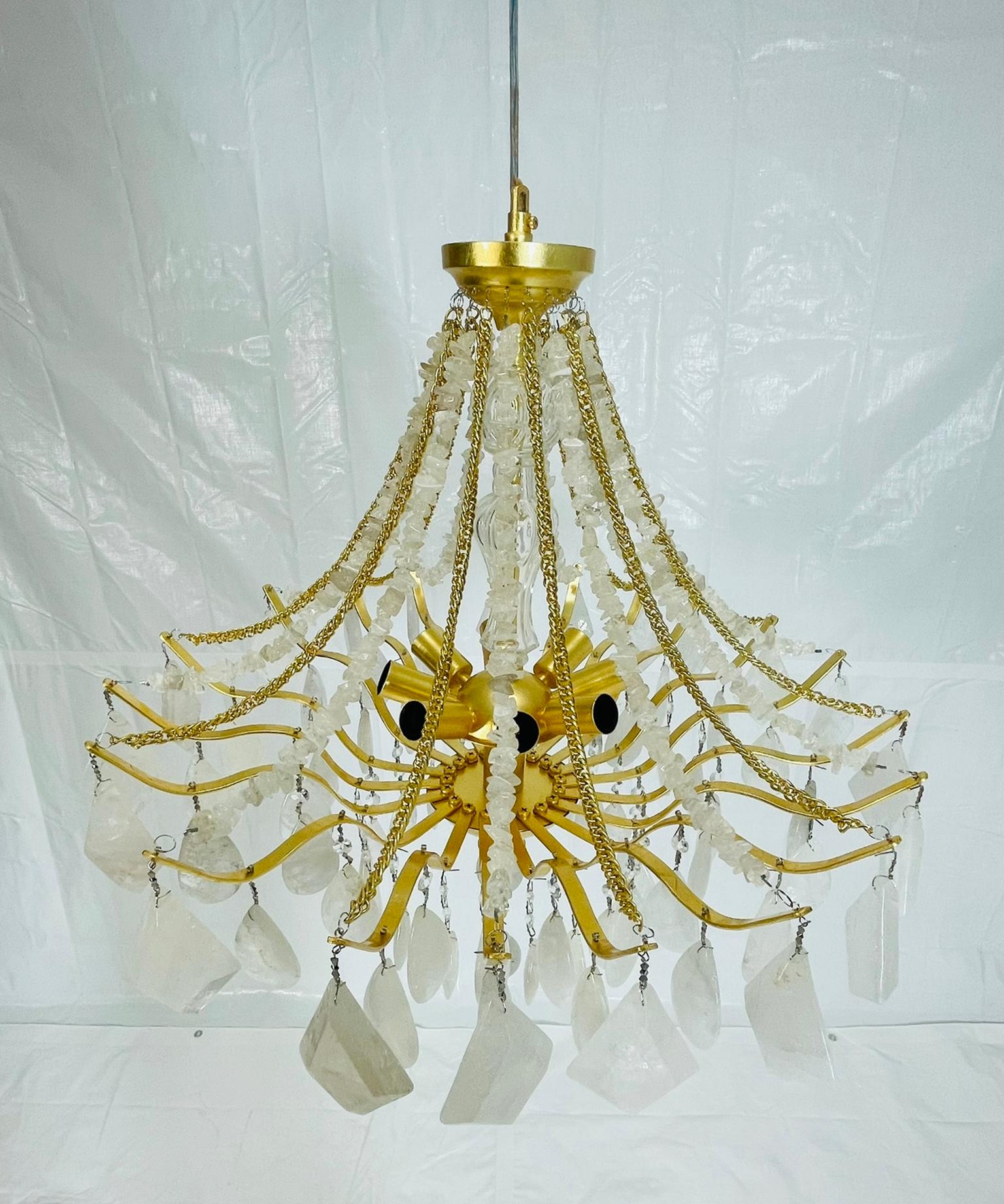 Elegant and sculptural “Vienna” chandelier designed and handcrafted by House of Aurah, featuring an exquisite combination of natural crystal quartz and gold leaf–finished metalwork. The design showcases gracefully draped strands of hand-cut quartz