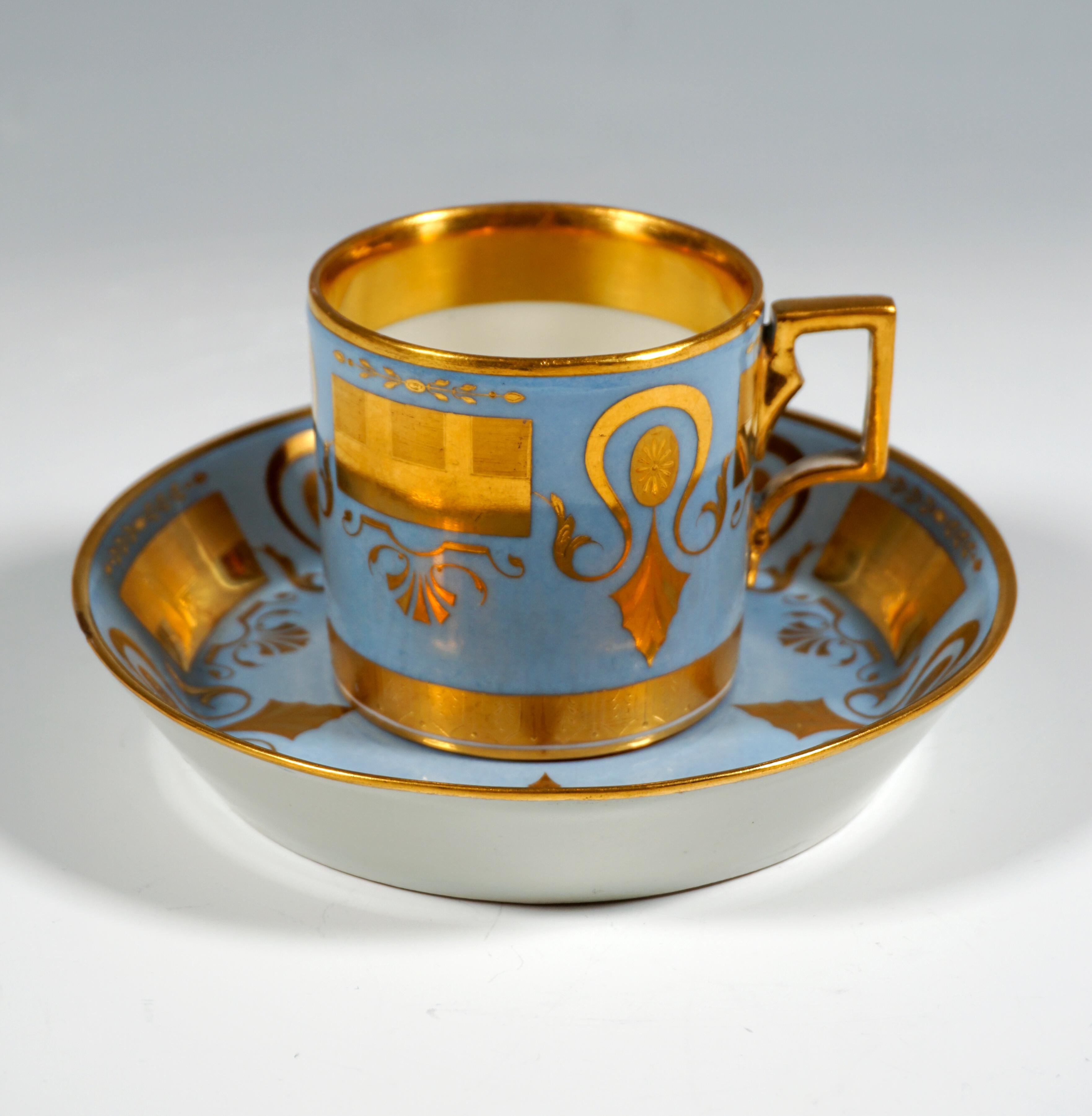 Cylindrical cup, the outside provided with a light blue background, thereon plentiful gold on gold painting in Empire style: horseshoe-shaped loops with feathered leaf ends enclosing small oval medallions with leaves attached below, rectangular