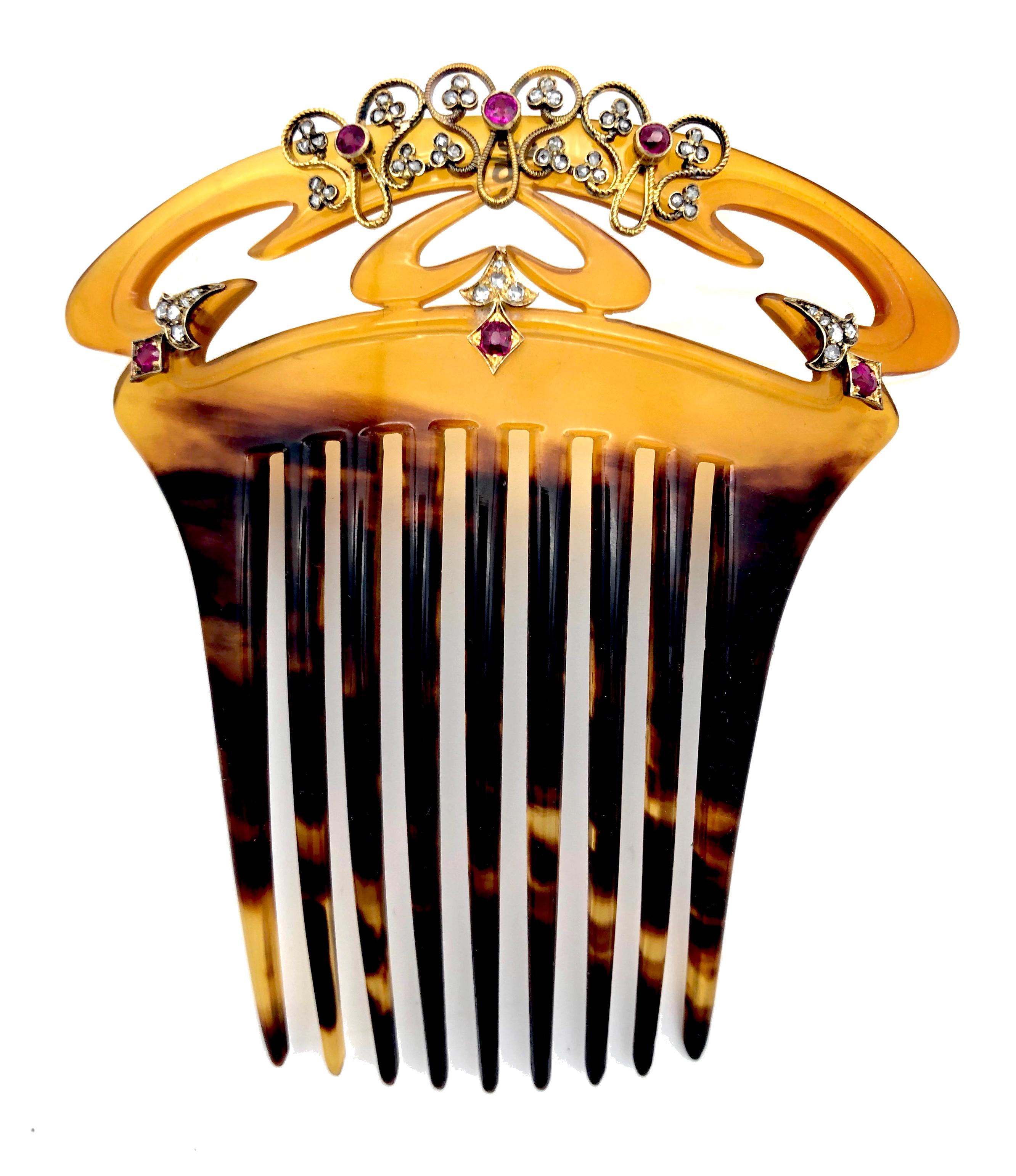 This exquisite carved tortoise shell hair comb is decorated with undulated, chiselled gold wire which is embellished with three gold set round facetted rubies and twelve small three-leaf clovers set with old cut diamonds. Another three lozenge