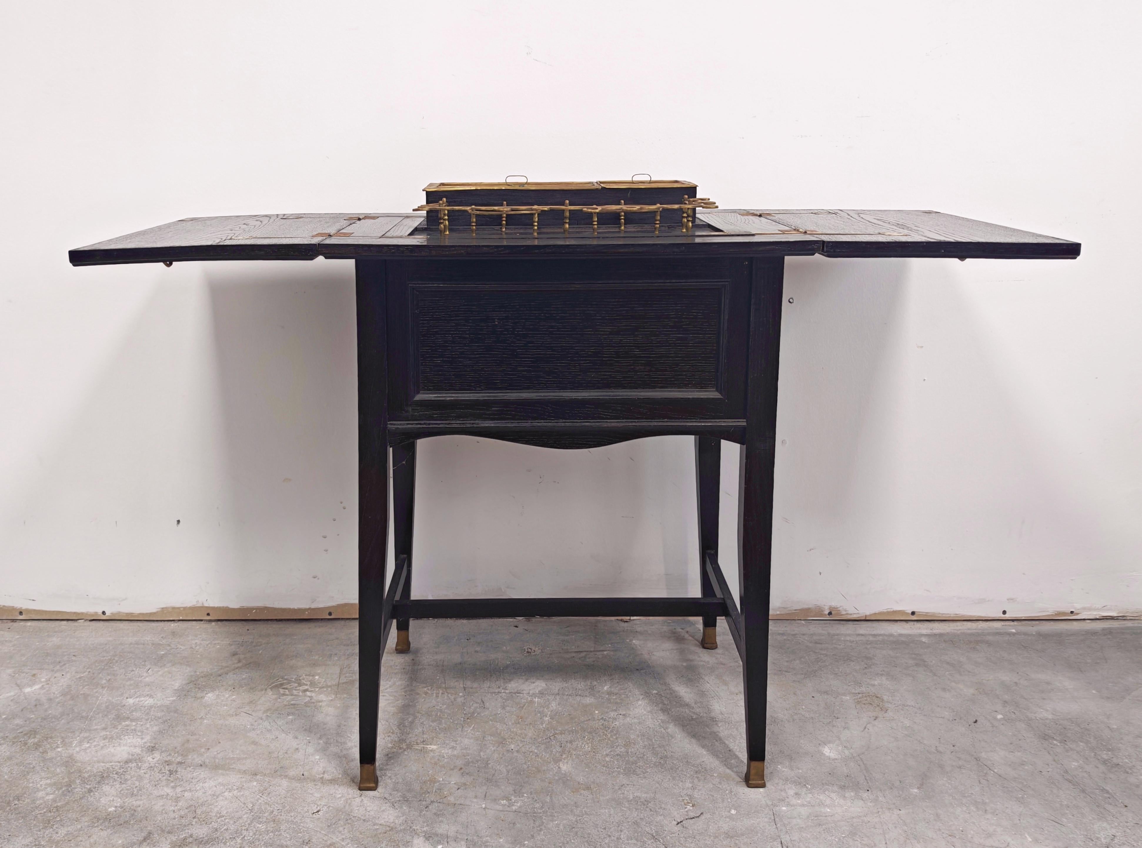 In questa inserzione troverai un mobile bar della Secessione viennese eccezionalmente raro, realizzato in rovere ebanizzato e con ferramenta in ottone. Il minibar è nascosto all'interno di quello che sembra essere un elegante tavolino, che solo