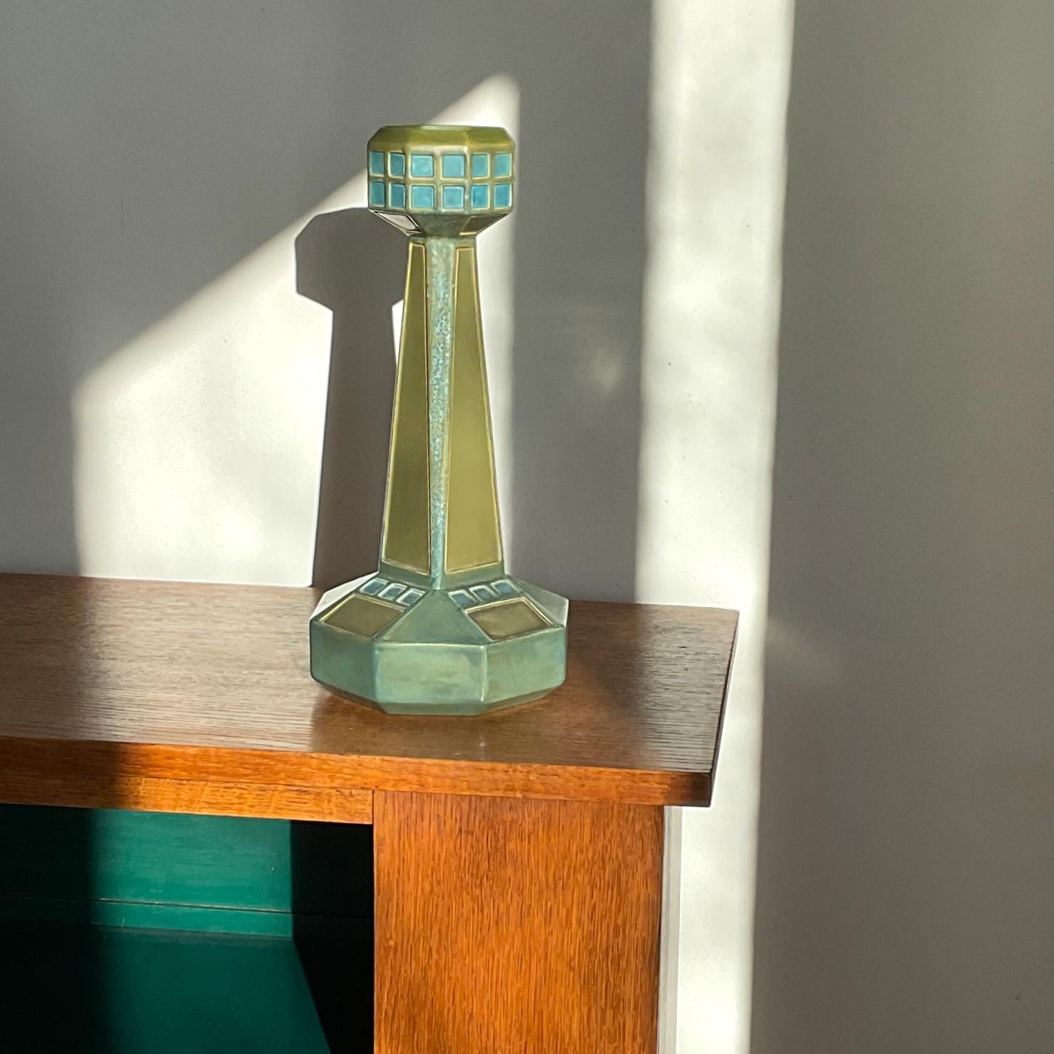 Un vase octogonal en faïence verte et bleue avec des carrés émaillés bleus, marqué Autriche et numéroté 7143. Ce type de vase a été fabriqué à l'école des arts appliqués de Vienne (Wiener Kunstgewerbeschule). Une pièce très décorative au design
