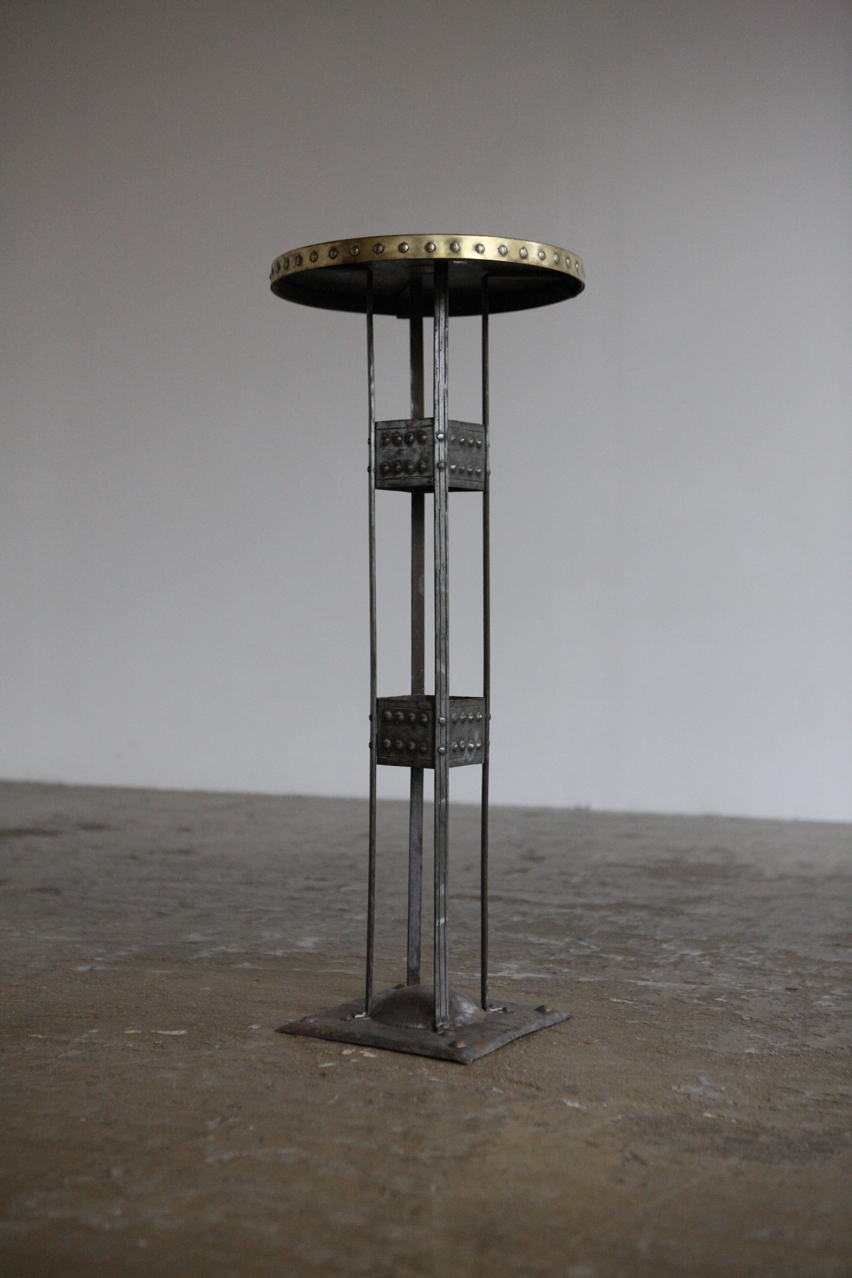 A mixed metal pedestal table straight out of the Vienna Secession period by Hugo Goberg. It features raised circle motifs to the top and stem, punched squares into the base and a beautifully hammered brass top.
