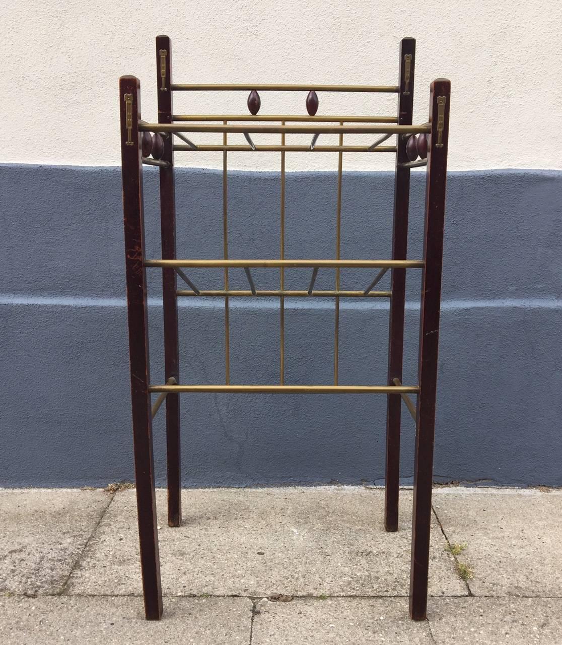 This Secessionist magazine, shoe or sheet music rack or shelf was made in Vienna, Austria during the early 1900s by an anonymous craftsman in the style of Koloman Moser. It is made from stained wood and brass.