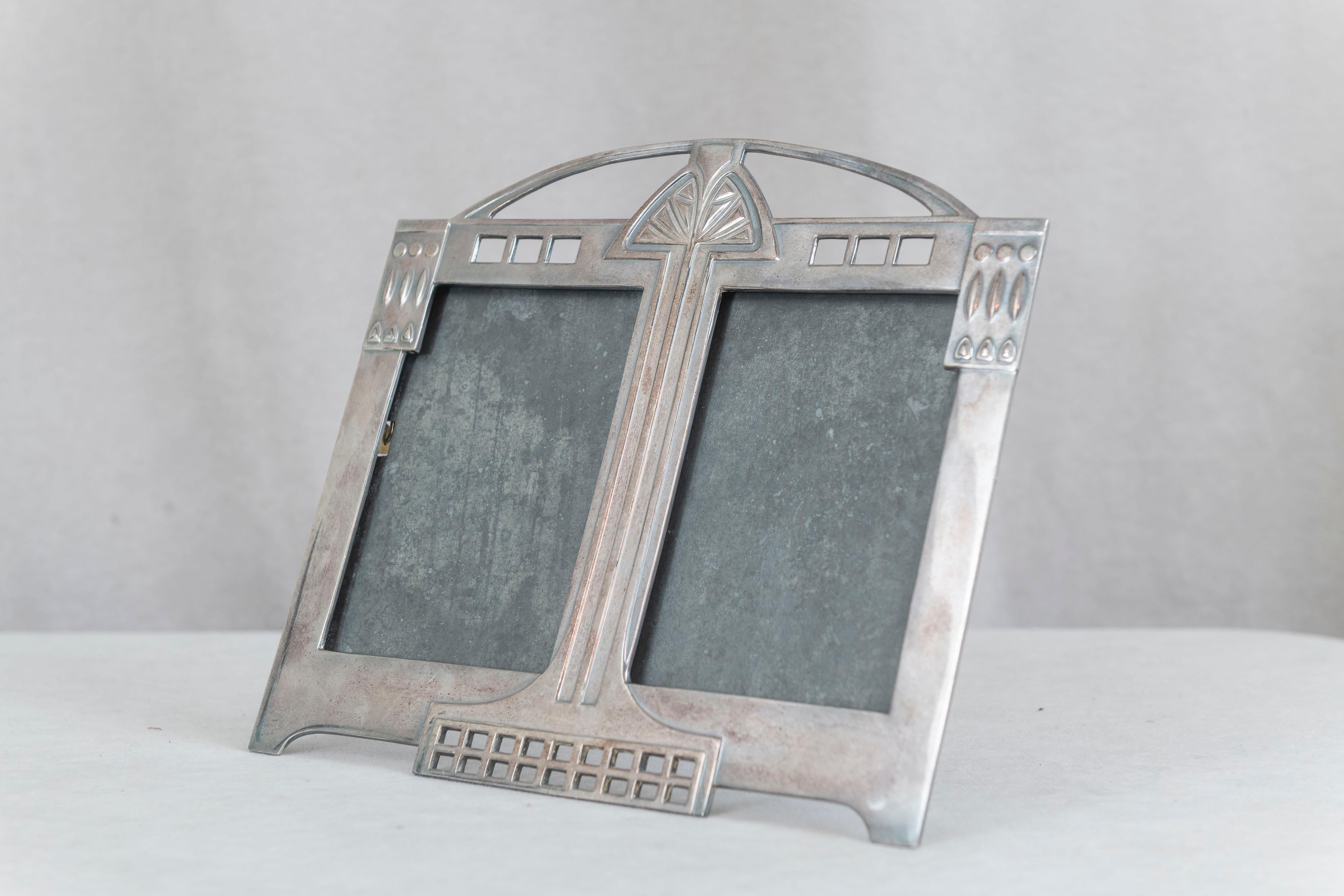  Un bien muy escaso. Un bonito marco doble de estilo secesionista vienés. Capta tanto la esencia del art déco como la del art nouveau. Chapado en plata sobre bronce y respaldo de caballete para utilizarlo sobre una mesa. 
  Una fina pieza de época