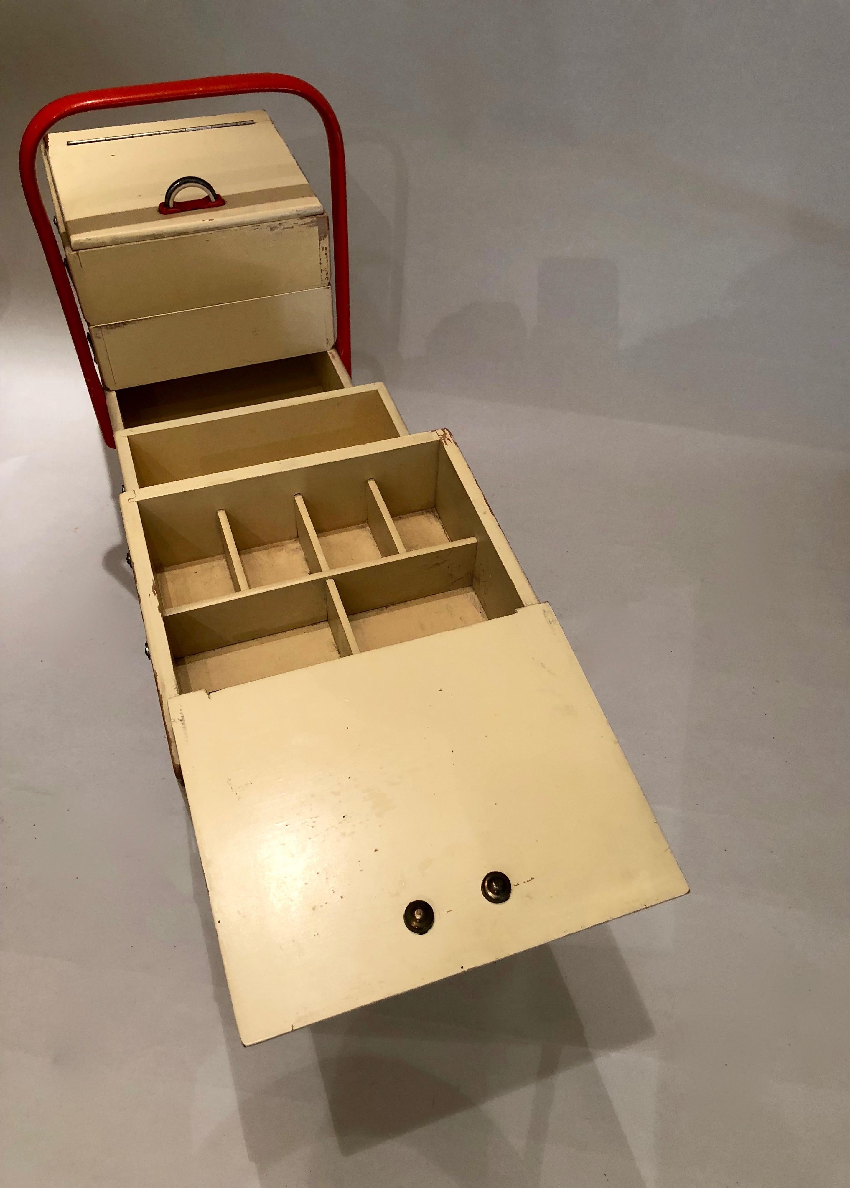 Sewing box with six folding drawers on wheels made of Bakelite.
Lacquered in coral and cream (Schleiflack); in original condition with beautiful patina.