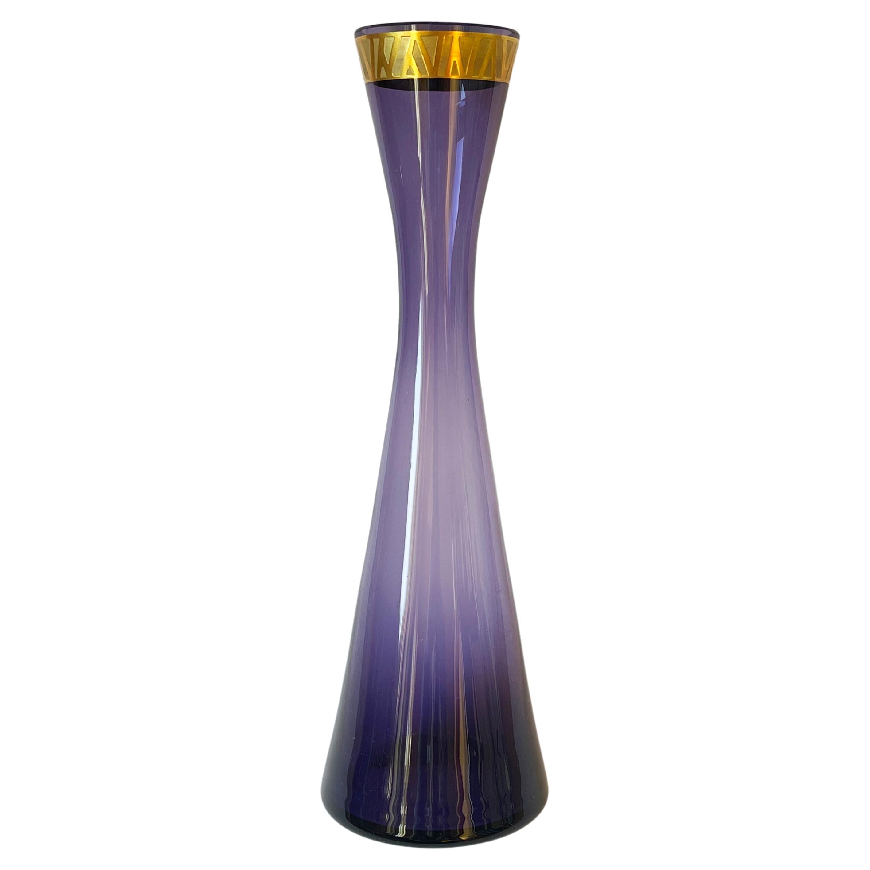 Fantastique, placé à l'époque du verre d'art allemand du milieu du siècle.
Le vase est en verre violet, le bord est taillé à la main, la frise dorée au sommet est tout simplement magnifique dans sa simplicité.
Les lignes les plus brillantes du