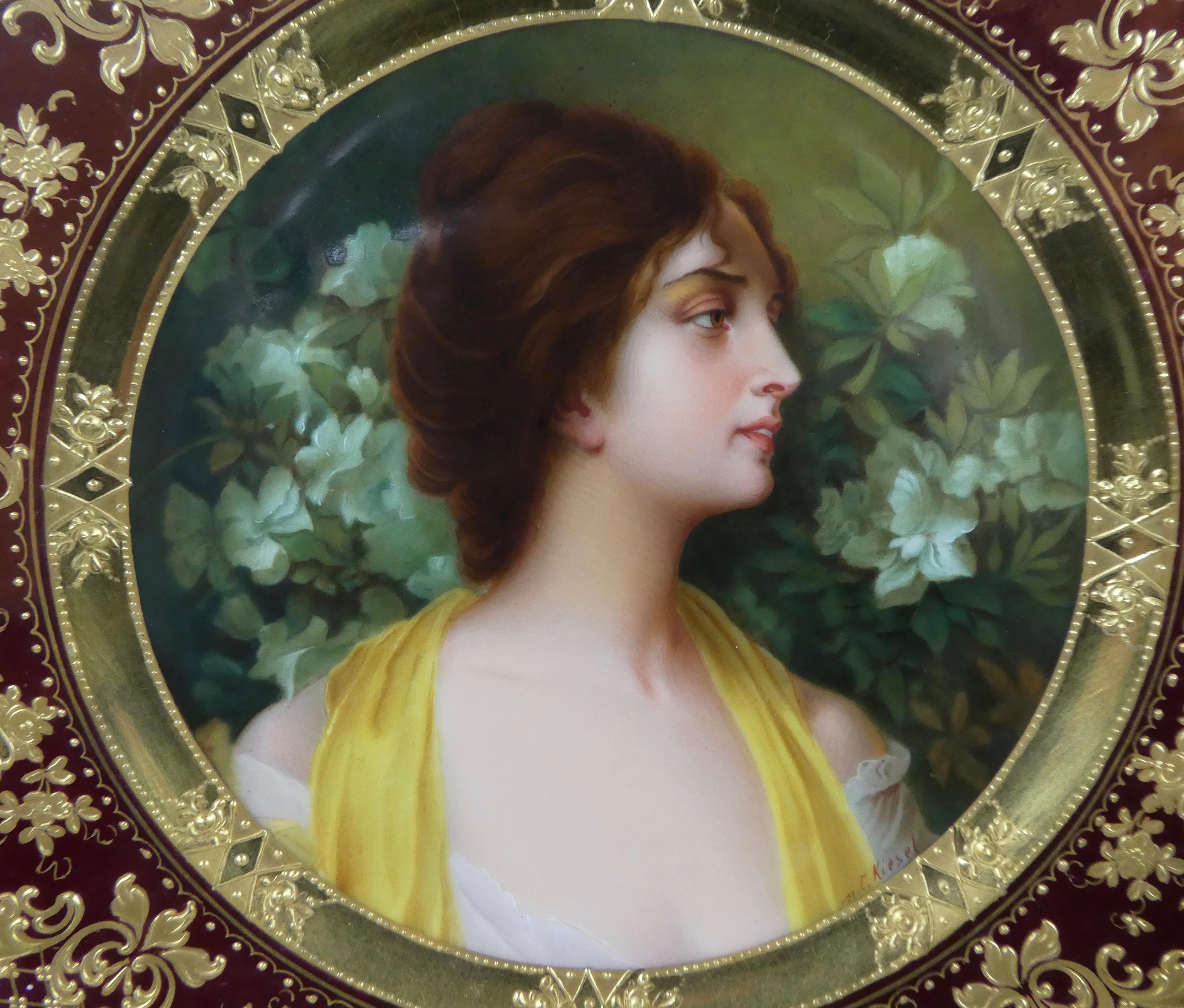 A Dresden Porcelain plate, circa 1900. Finely painted in the Vienna style, with a titled portrait of ‘Azalee’, by C. Kiesel. Within a burgundy ground border, finely gilded with cornucopia, amongst elaborate scrollwork.
Signed - C. Kiesel.
Printed