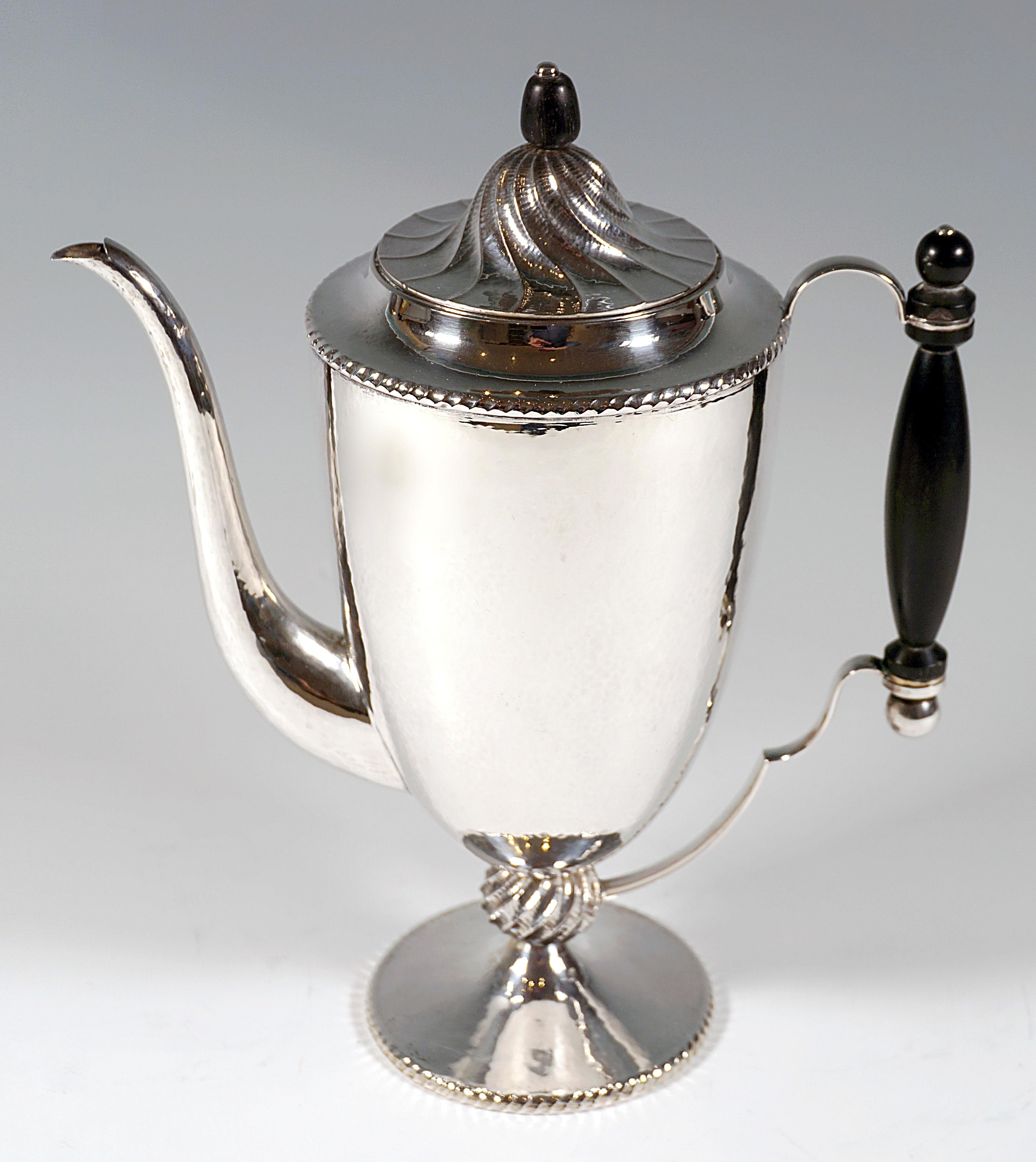 Excellent, elegant silver coffee pot in the style of Dagobert Peche's designs:
Raised, widening vessel on a stepped, funnel-shaped base, connected by a beaded ring with hammered, spirally chased grooves, cord band border on the foot rim, as well as