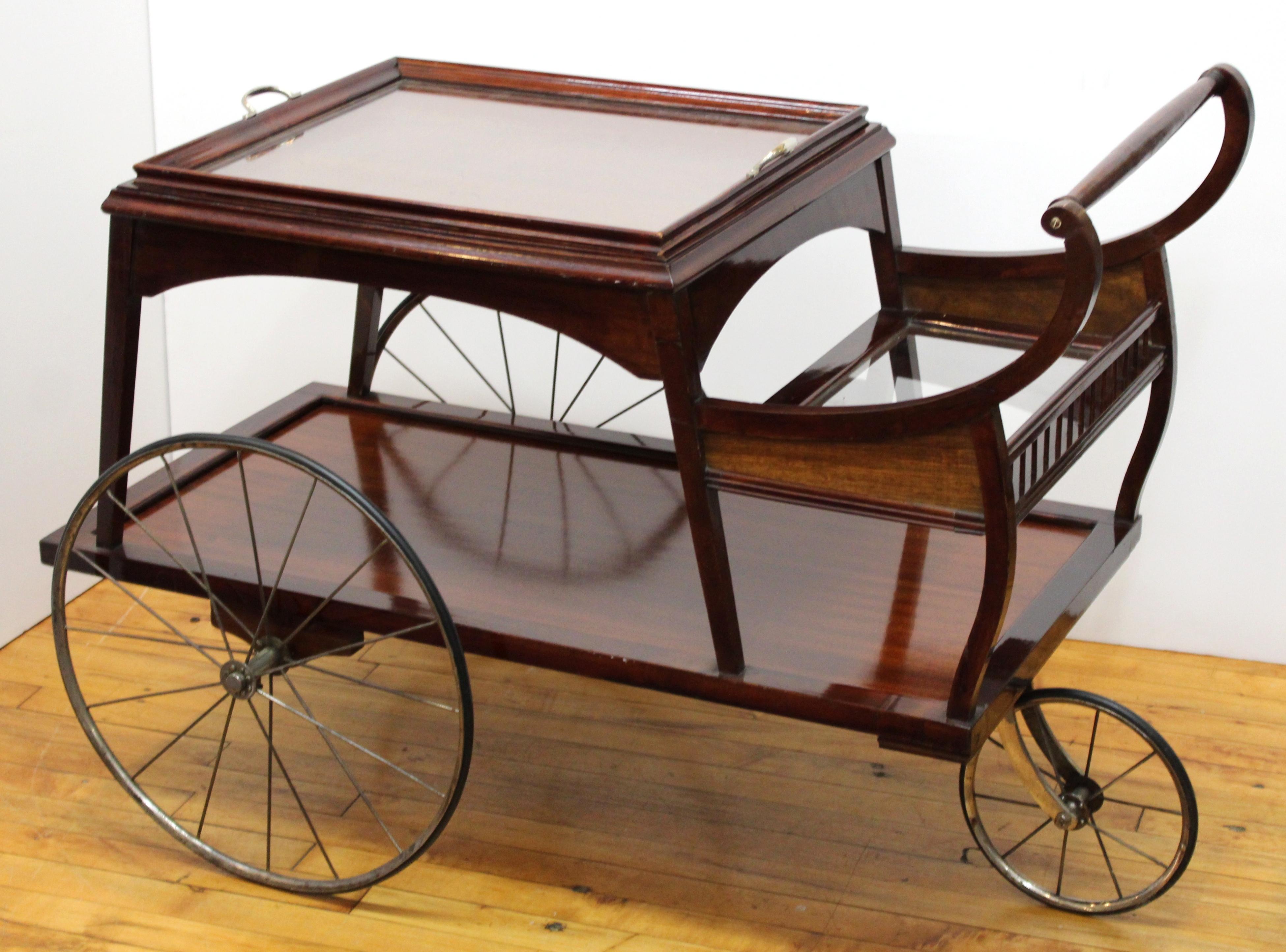 Viennese Art Nouveau period serving cart in wood, metal and glass, with a removable glass serving tray inserted on the top level and three spoke wheels. The piece was made in circa 1902 in Austria. In great condition with some age-appropriate wear