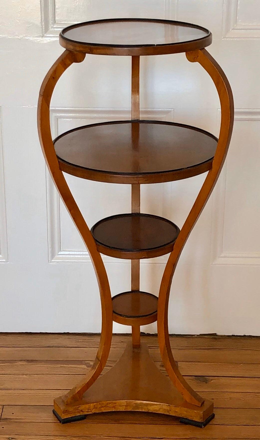 This elegant Viennese étagère is made of cherry-veneer with ebony feet and cock-bead around the edge of each of the four shelves. The graceful lines of this étagère are similar to a watercolor drawing for an étagère by Josef Danhauser. The graceful